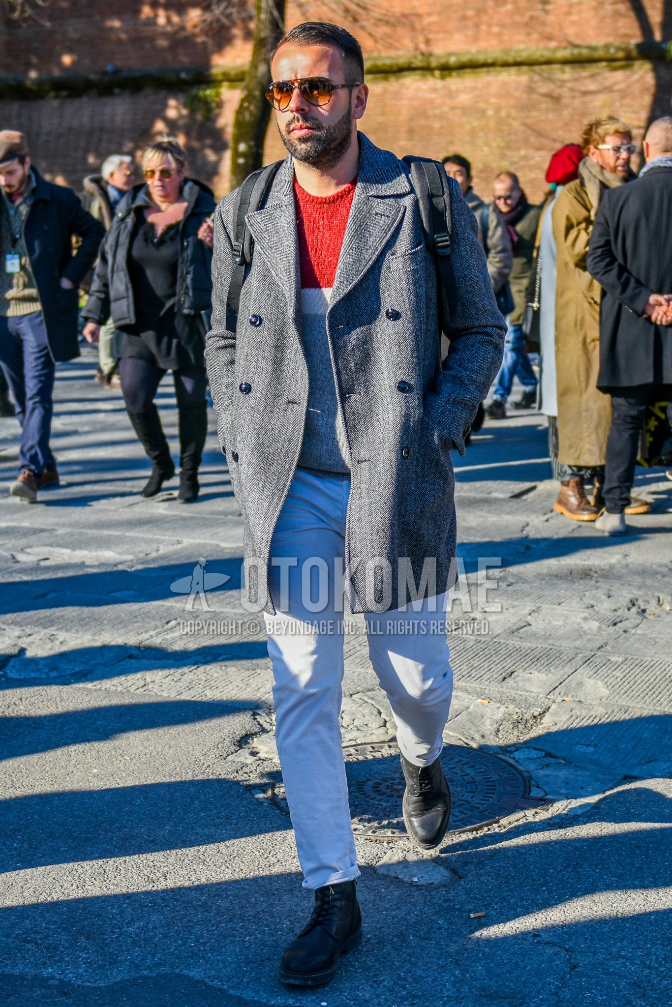 Men's autumn winter outfit with brown tortoiseshell sunglasses, gray plain chester coat, red white gray horizontal stripes sweater, white plain denim/jeans, black work boots.