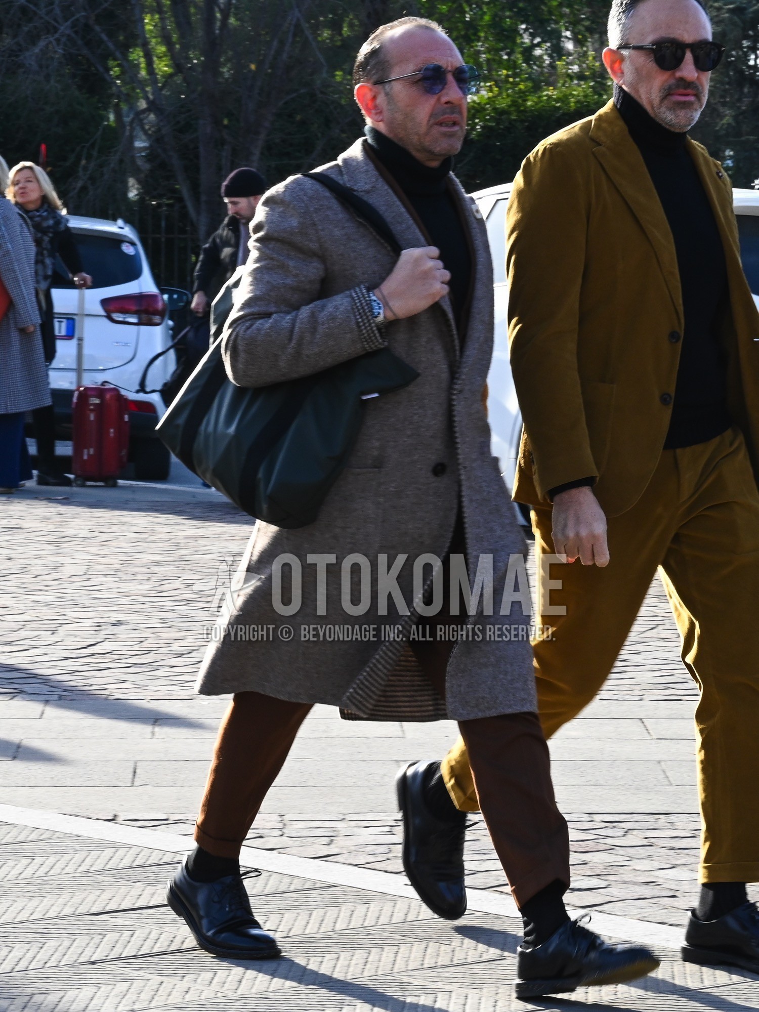 Men's autumn winter outfit with navy plain sunglasses, gray plain chester coat, black plain turtleneck knit, black plain socks, olive green plain tote bag, brown plain suit.