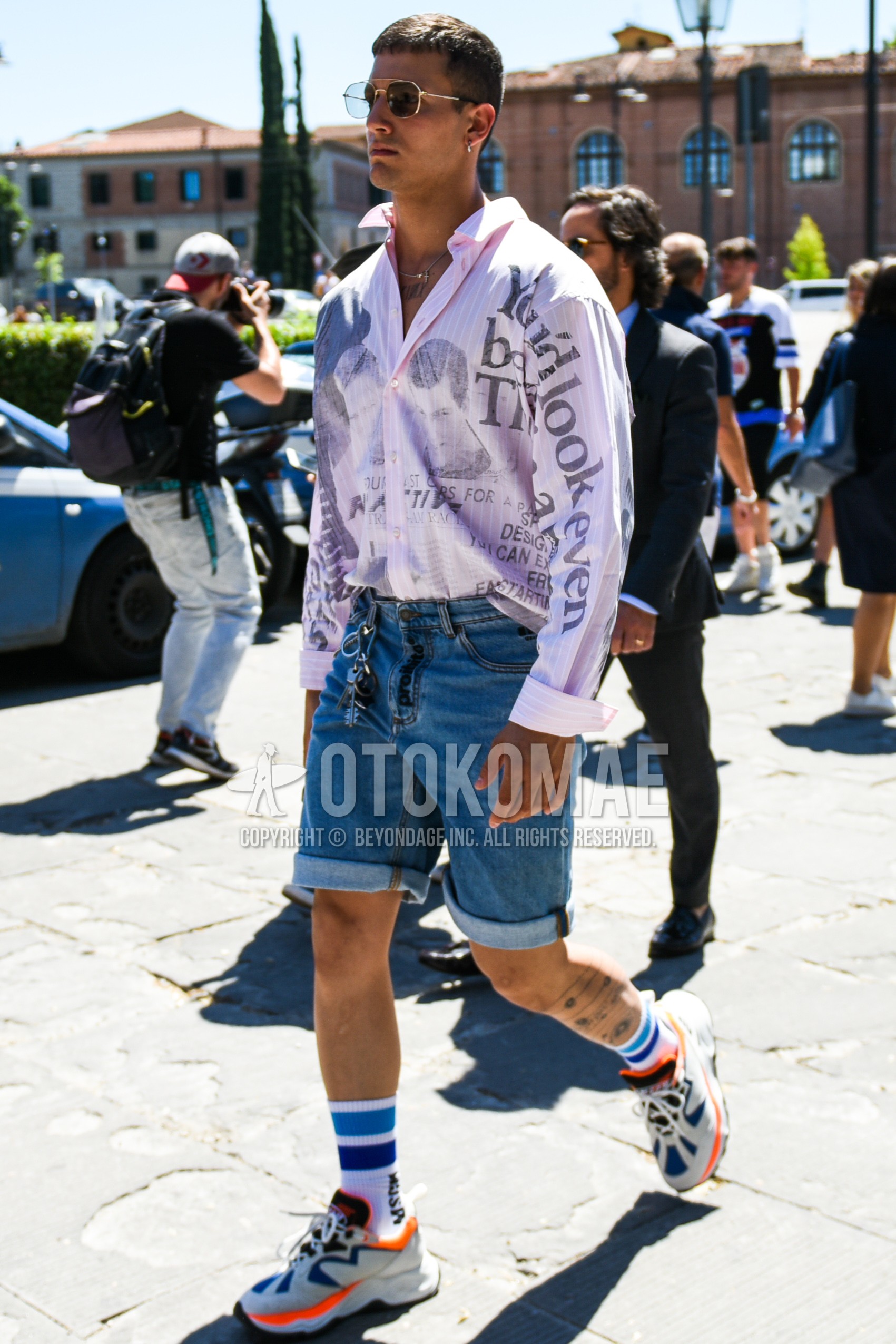 Men's spring summer outfit with pink graphic shirt, blue plain denim/jeans, plain short pants, white one point socks, white low-cut sneakers.