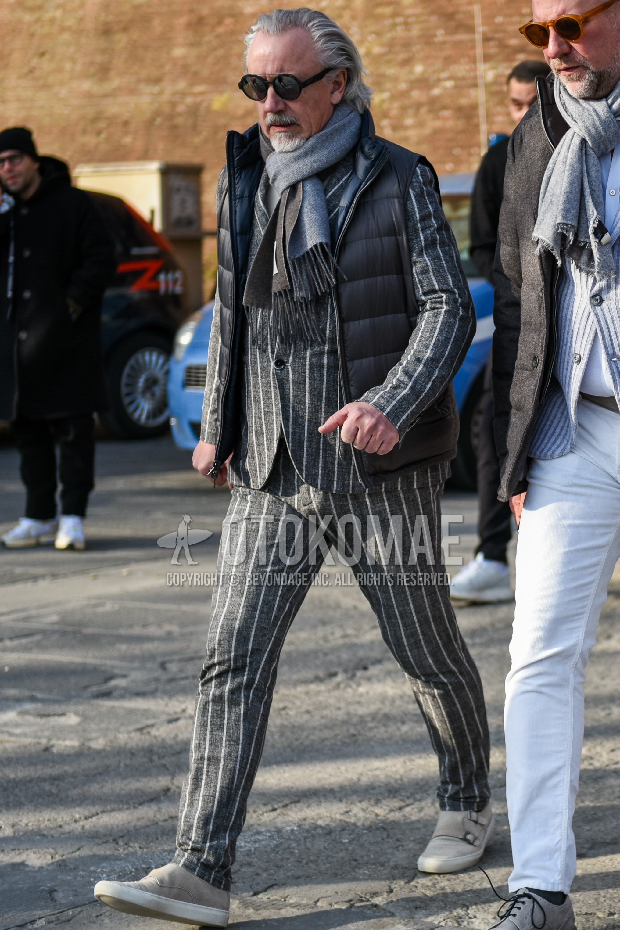 Men's autumn winter outfit with black plain sunglasses, gray plain scarf, gray plain down jacket, gray plain casual vest, gray low-cut sneakers, gray stripes suit.