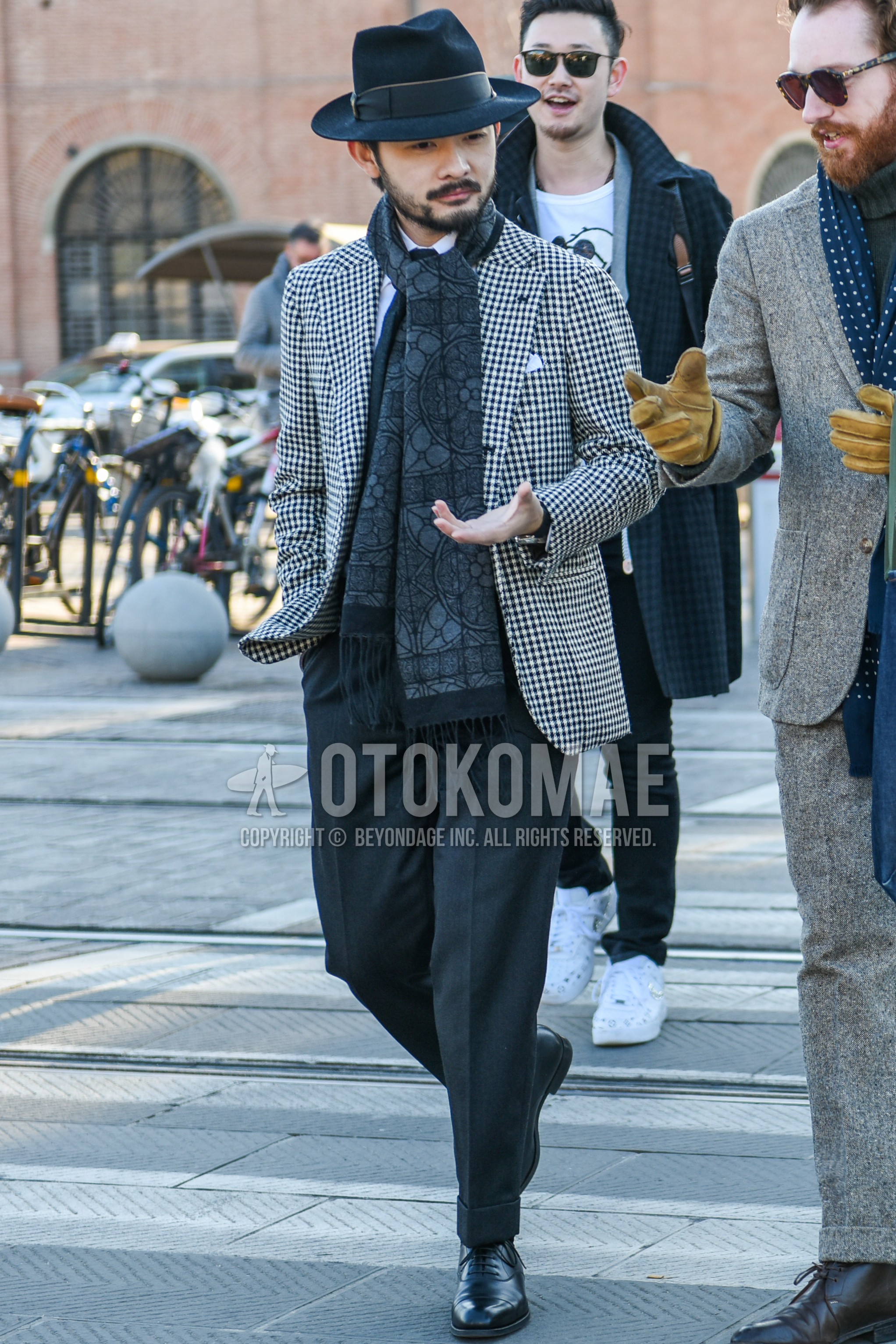 Men's spring autumn outfit with black plain hat, dark gray scarf scarf, white black check tailored jacket, gray plain slacks, black straight-tip shoes leather shoes.