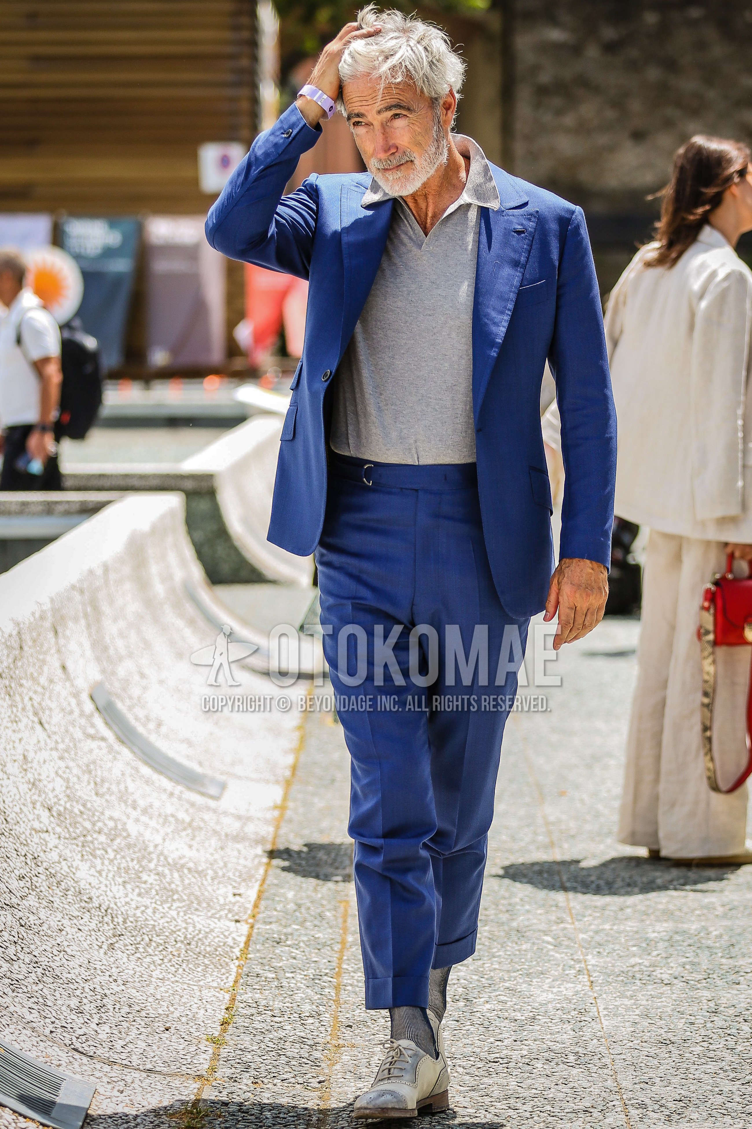 Men's spring summer outfit with gray plain polo shirt, white brogue shoes leather shoes, blue stripes suit.