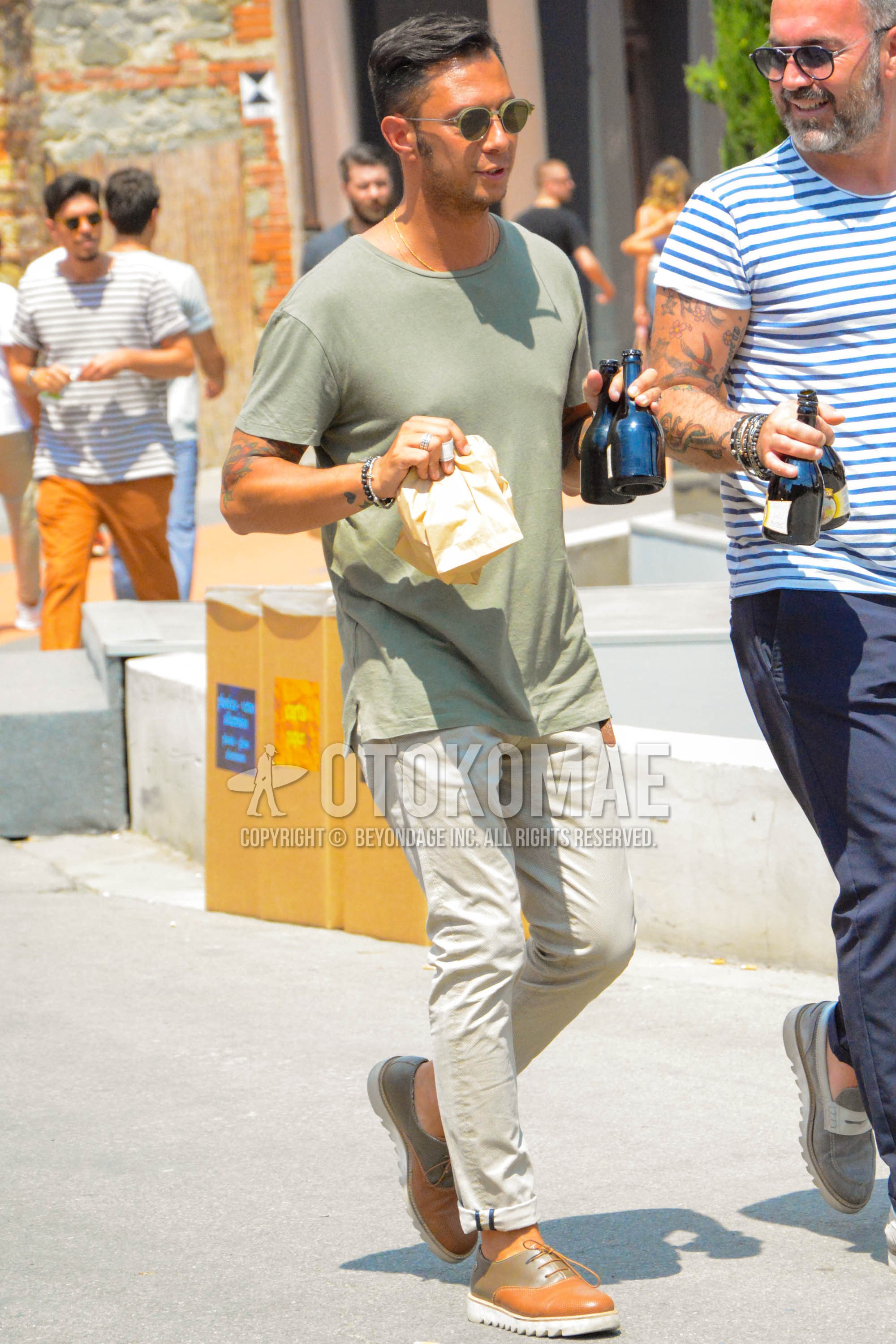 Men's summer outfit with plain sunglasses, olive green plain t-shirt, beige plain chinos, orange plain toe leather shoes.