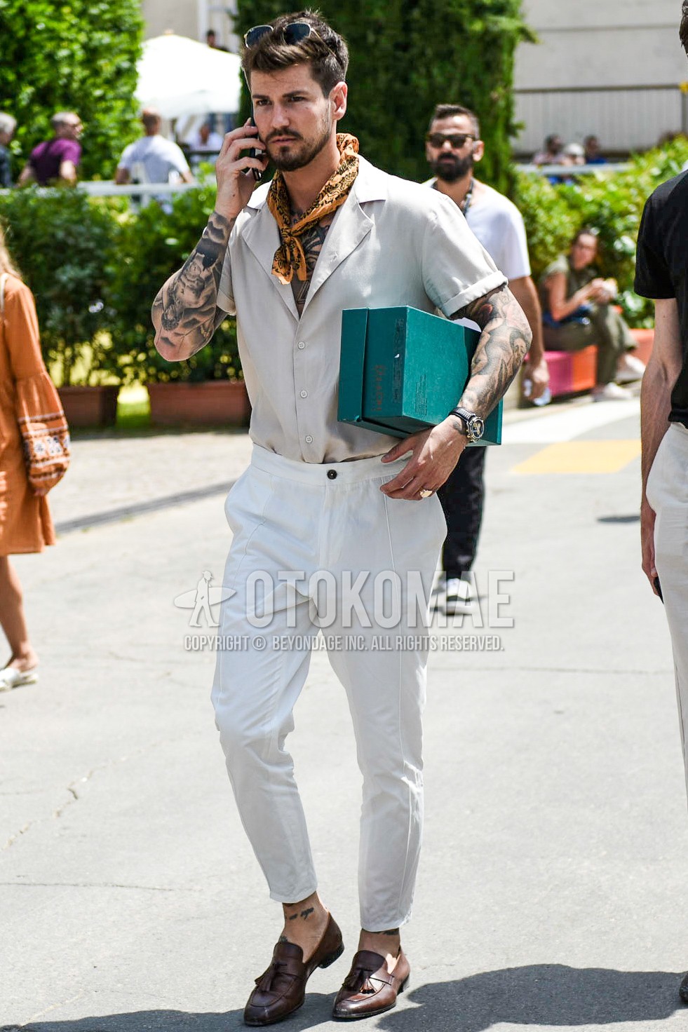 Men's summer outfit with beige paisley bandana/neckerchief, beige plain shirt, white plain ankle pants, plain slacks, brown tassel loafers leather shoes.