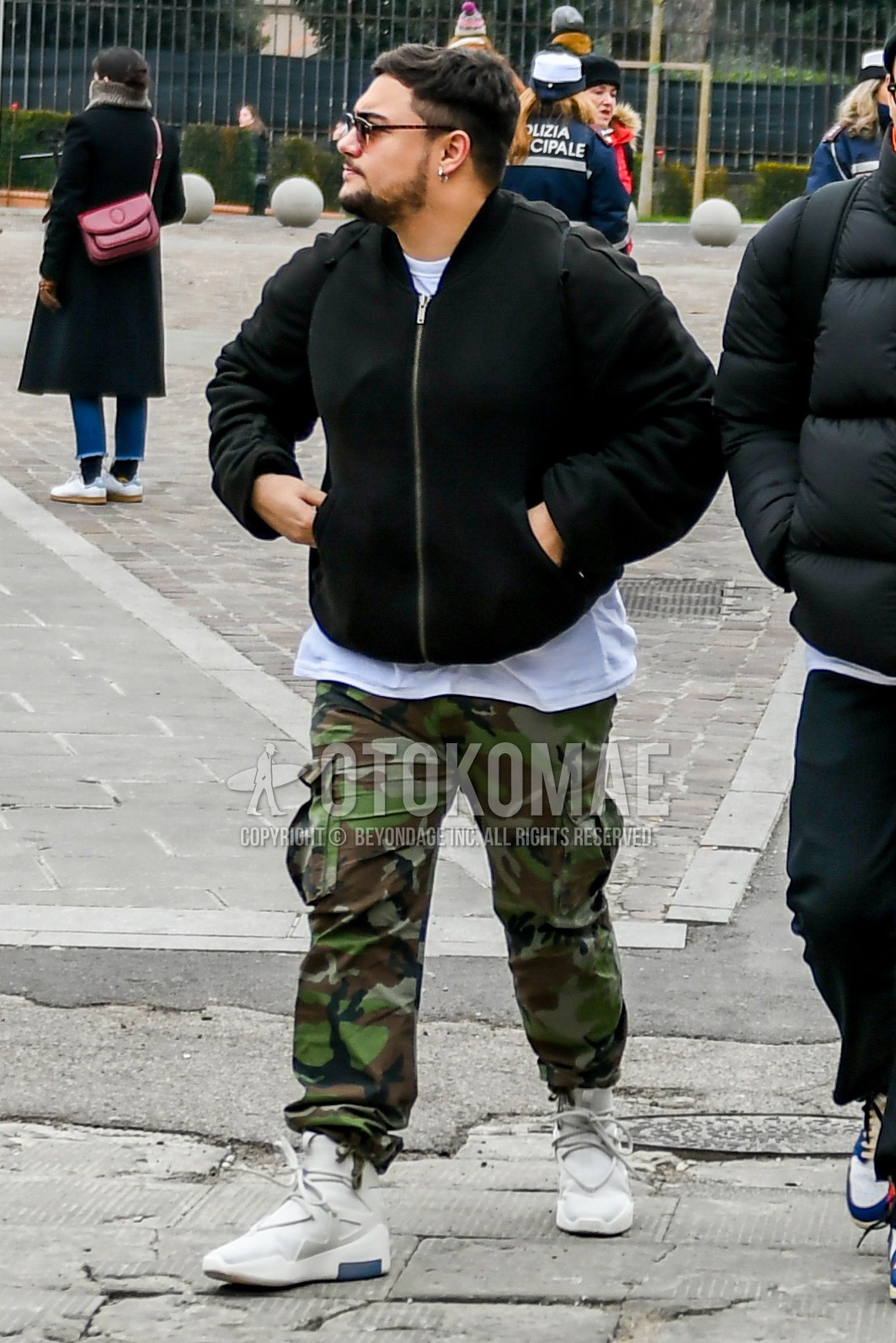 Men's winter outfit with plain sunglasses, black plain MA-1, white plain t-shirt, green camouflage cargo pants, white high-cut sneakers.