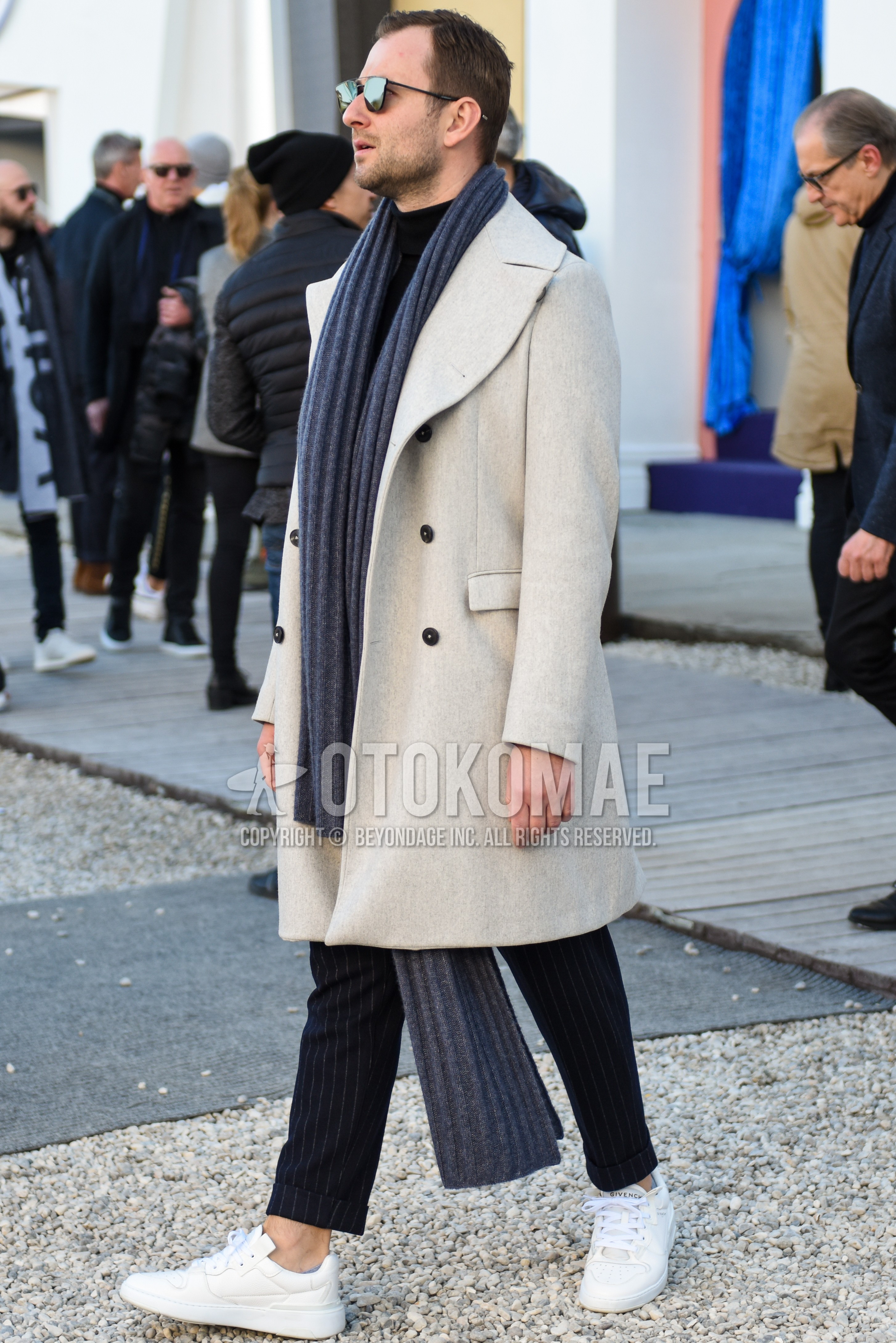 Men's autumn winter outfit with silver plain sunglasses, white plain ulster coat, dark gray stripes slacks, dark gray stripes ankle pants, white low-cut sneakers.