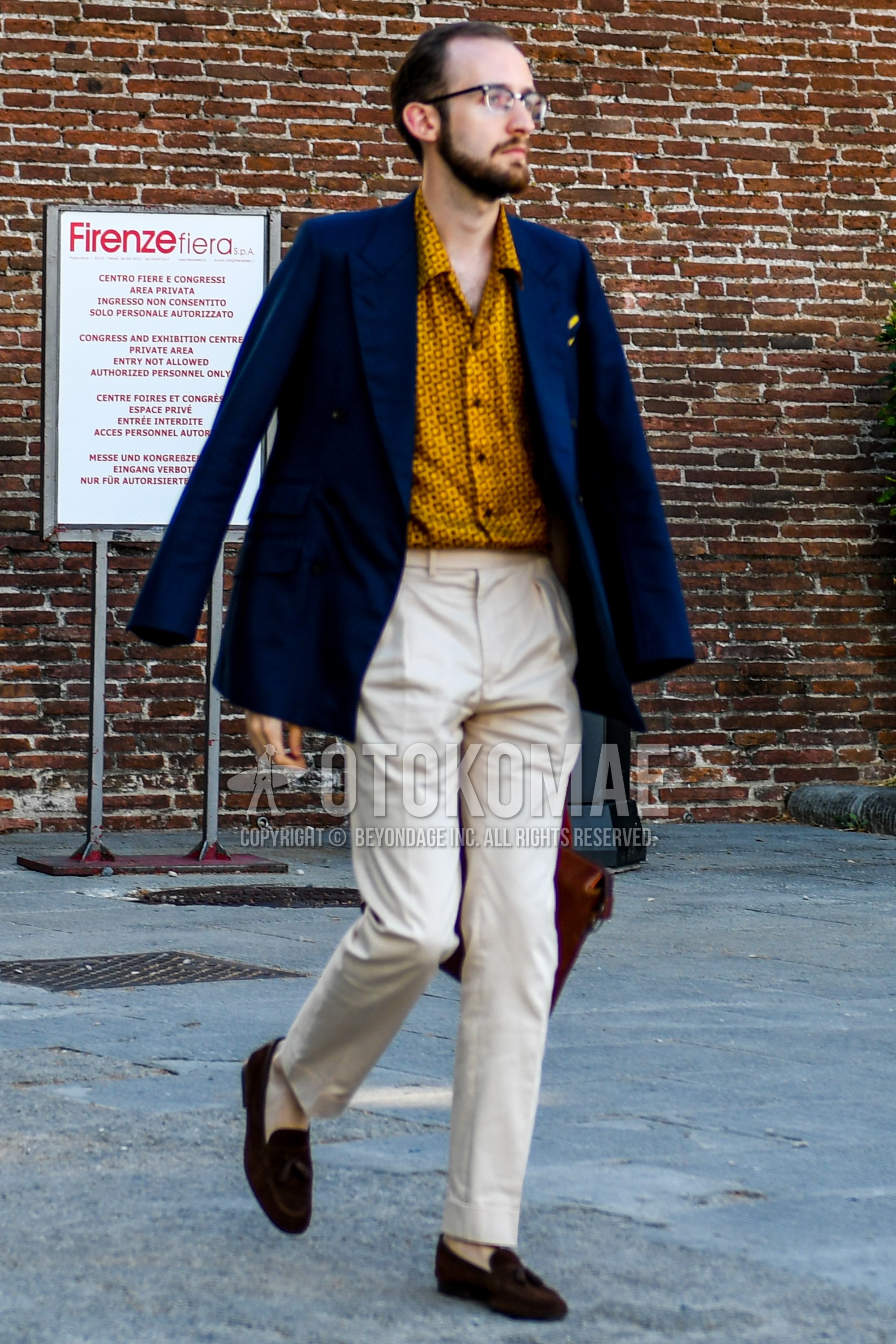 Men's spring autumn outfit with black plain glasses, navy plain tailored jacket, yellow tops/innerwear shirt, beige plain slacks, beige plain chinos, brown tassel loafers leather shoes.