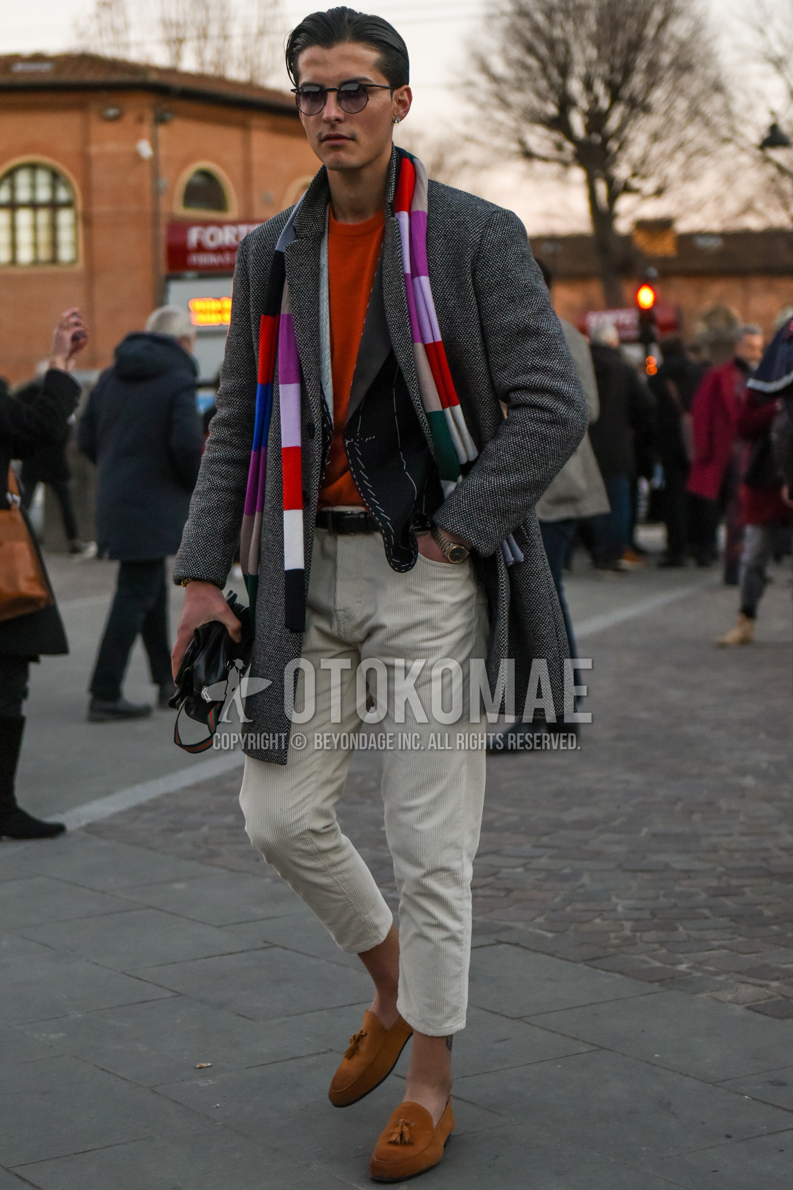 Men's autumn winter outfit with black plain sunglasses, multi-color scarf scarf, green outerwear chester coat, gray plain tailored jacket, orange plain sweater, black plain leather belt, beige plain winter pants (corduroy,velour), beige plain cropped pants, brown tassel loafers leather shoes.