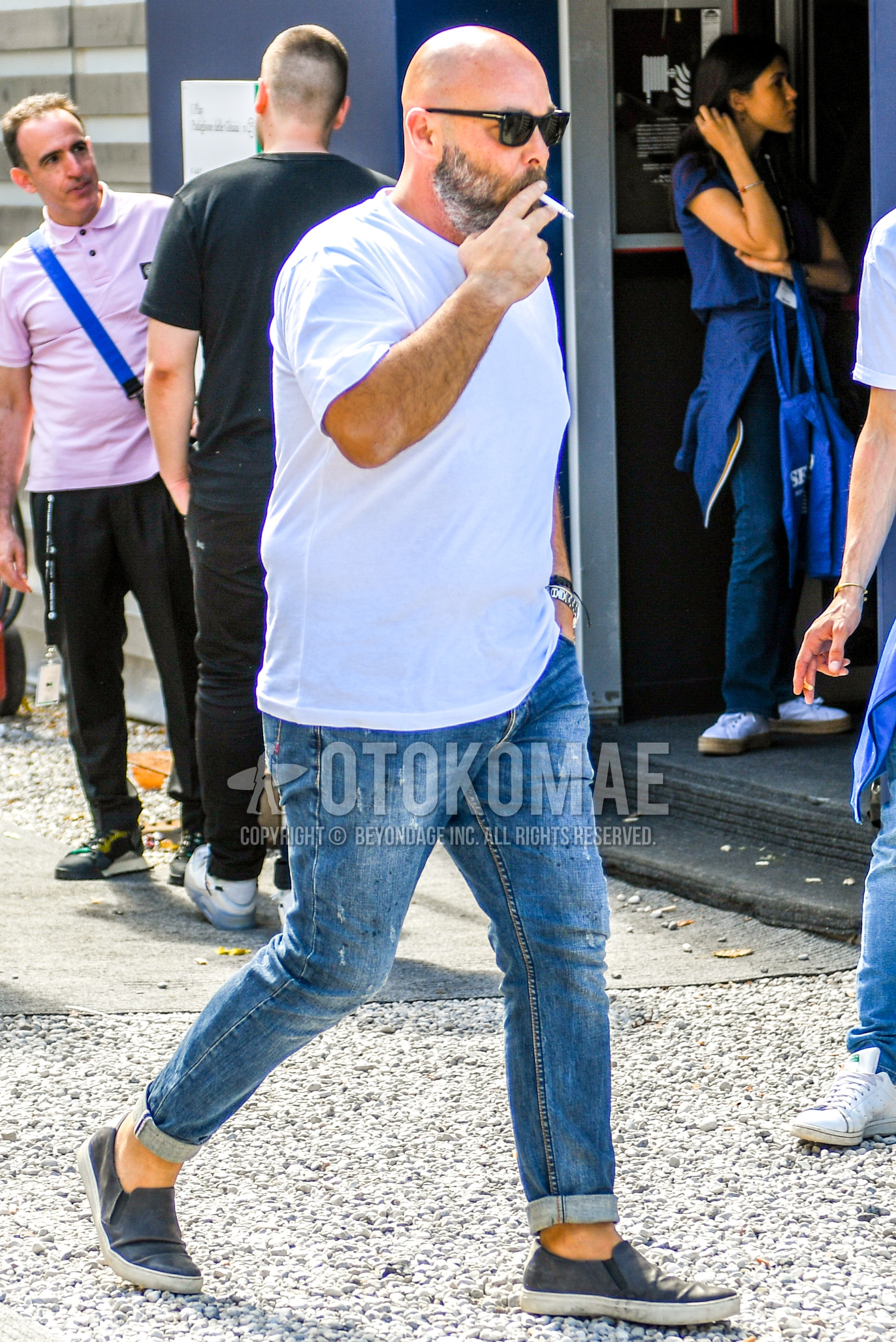 Men's summer outfit with plain sunglasses, white plain t-shirt, blue plain denim/jeans, gray slip-on sneakers.