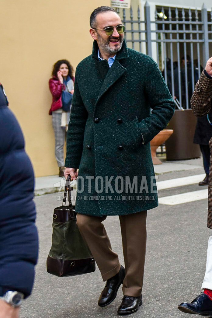Men's winter outfit with plain sunglasses, green herringbone chester coat, brown plain slacks, brown u-tip shoes leather shoes, brown olive green plain tote bag.