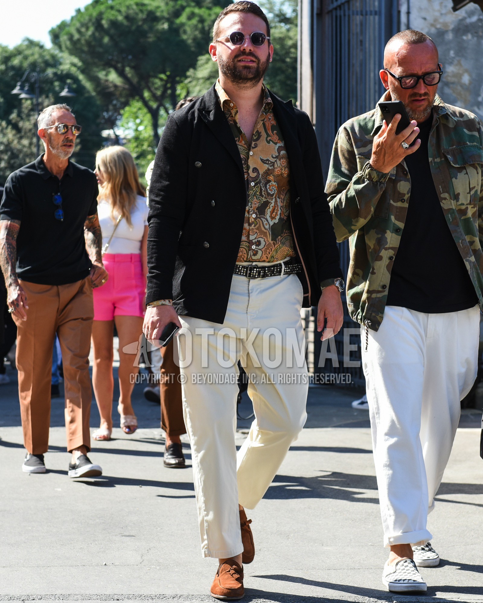 Men's spring summer outfit with silver plain sunglasses, black plain tailored jacket, brown botanical shirt, plain leather belt, white plain cotton pants, brown tassel loafers leather shoes, brown suede shoes leather shoes.