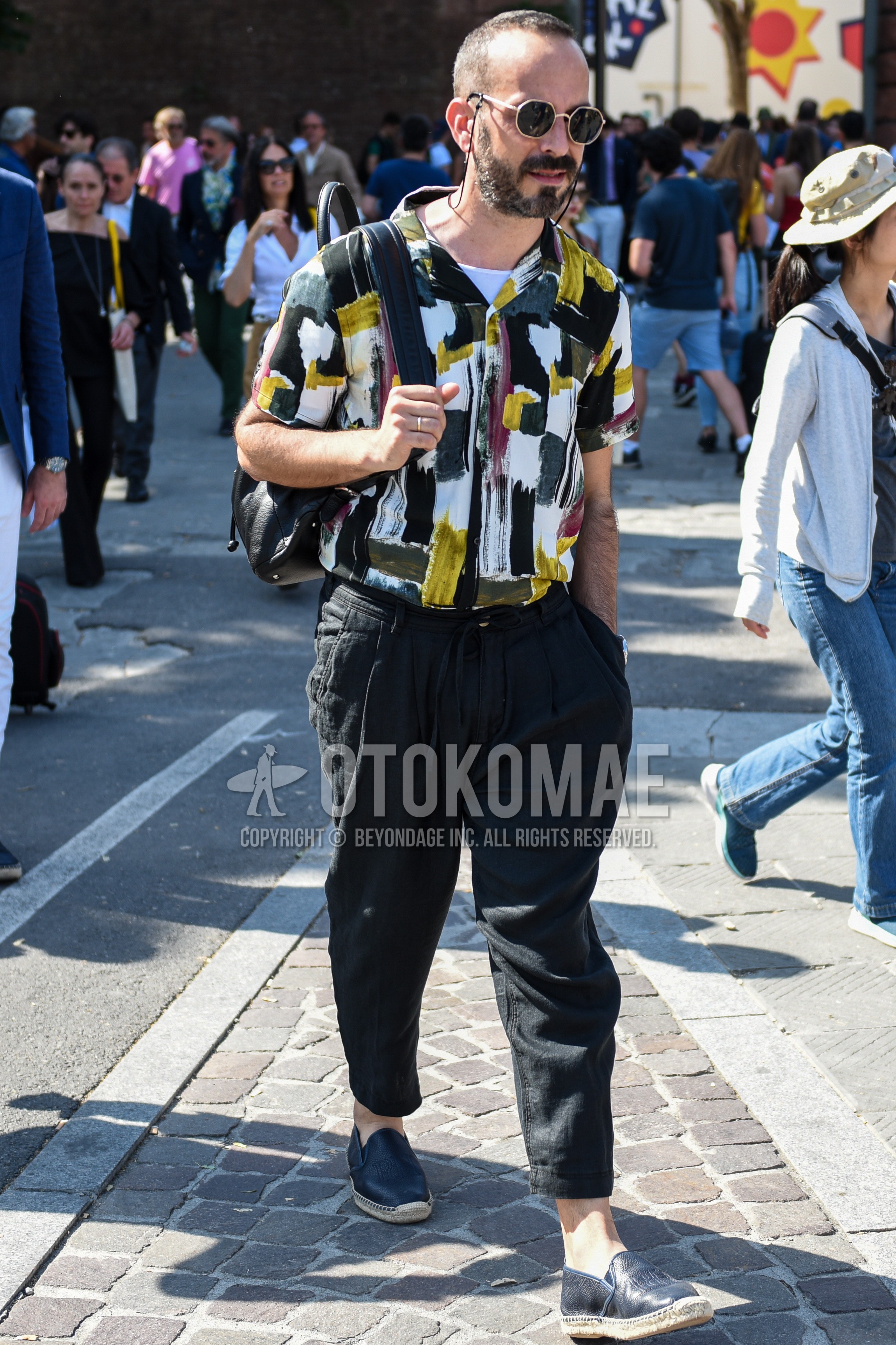 Men's summer outfit with gold black plain sunglasses, multi-color tops/innerwear shirt, black plain ankle pants, black plain espadrille.