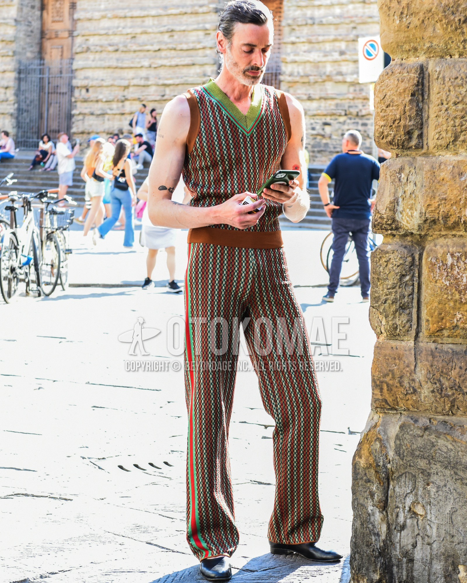 Men's spring summer outfit with black leather sandals, brown green stripes casual setup.