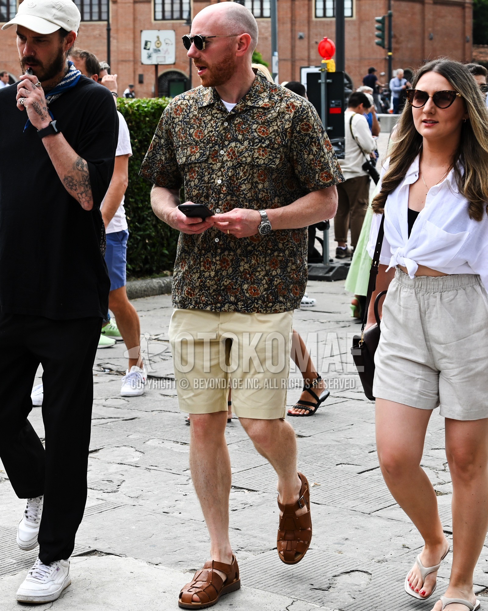 Men's spring summer autumn outfit with black plain sunglasses, green tops/innerwear shirt, white plain t-shirt, white plain short pants, brown gurkha sandals.