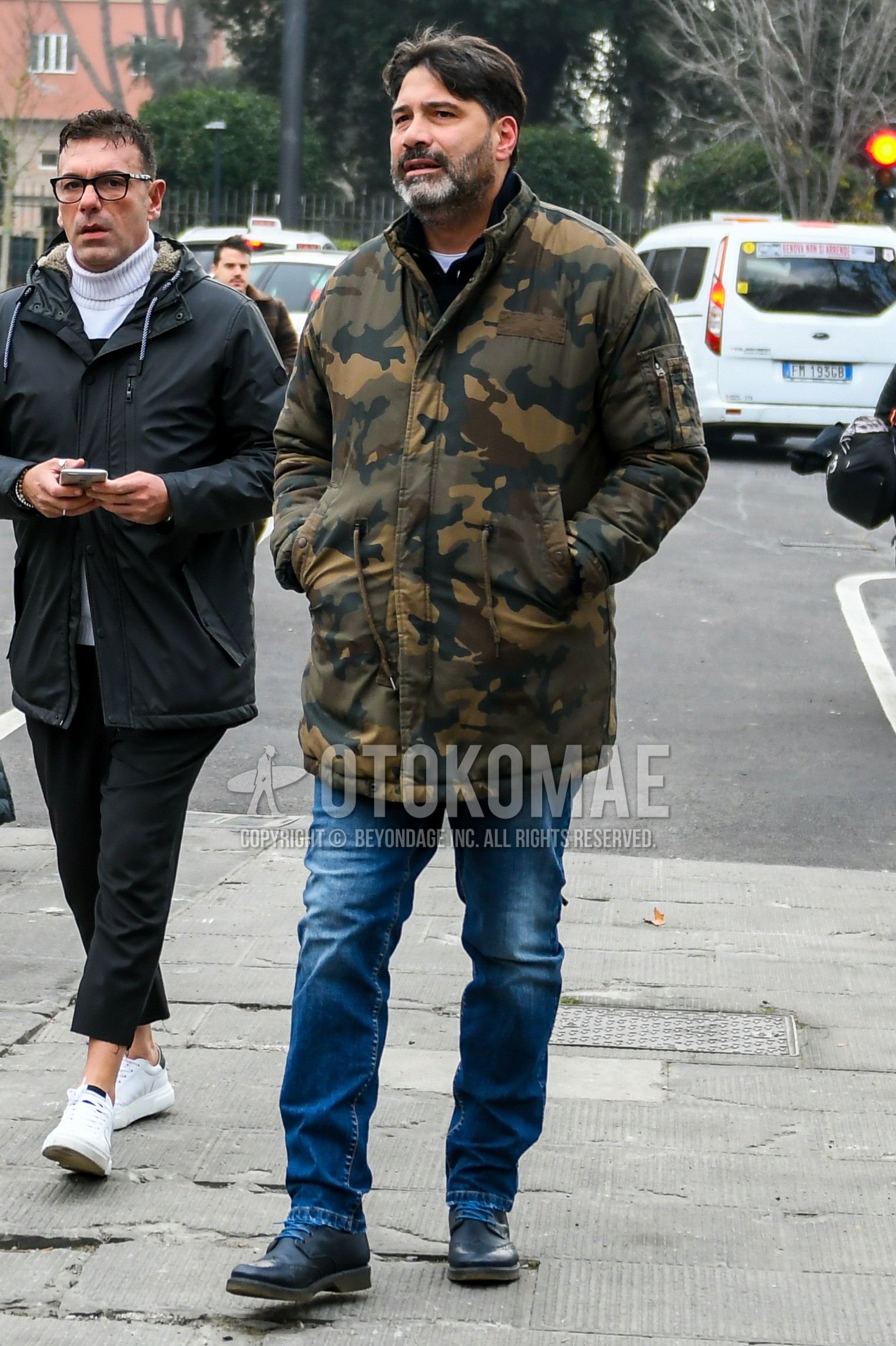 Men's autumn winter outfit with multi-color camouflage down jacket, blue plain denim/jeans, navy wing-tip shoes leather shoes.