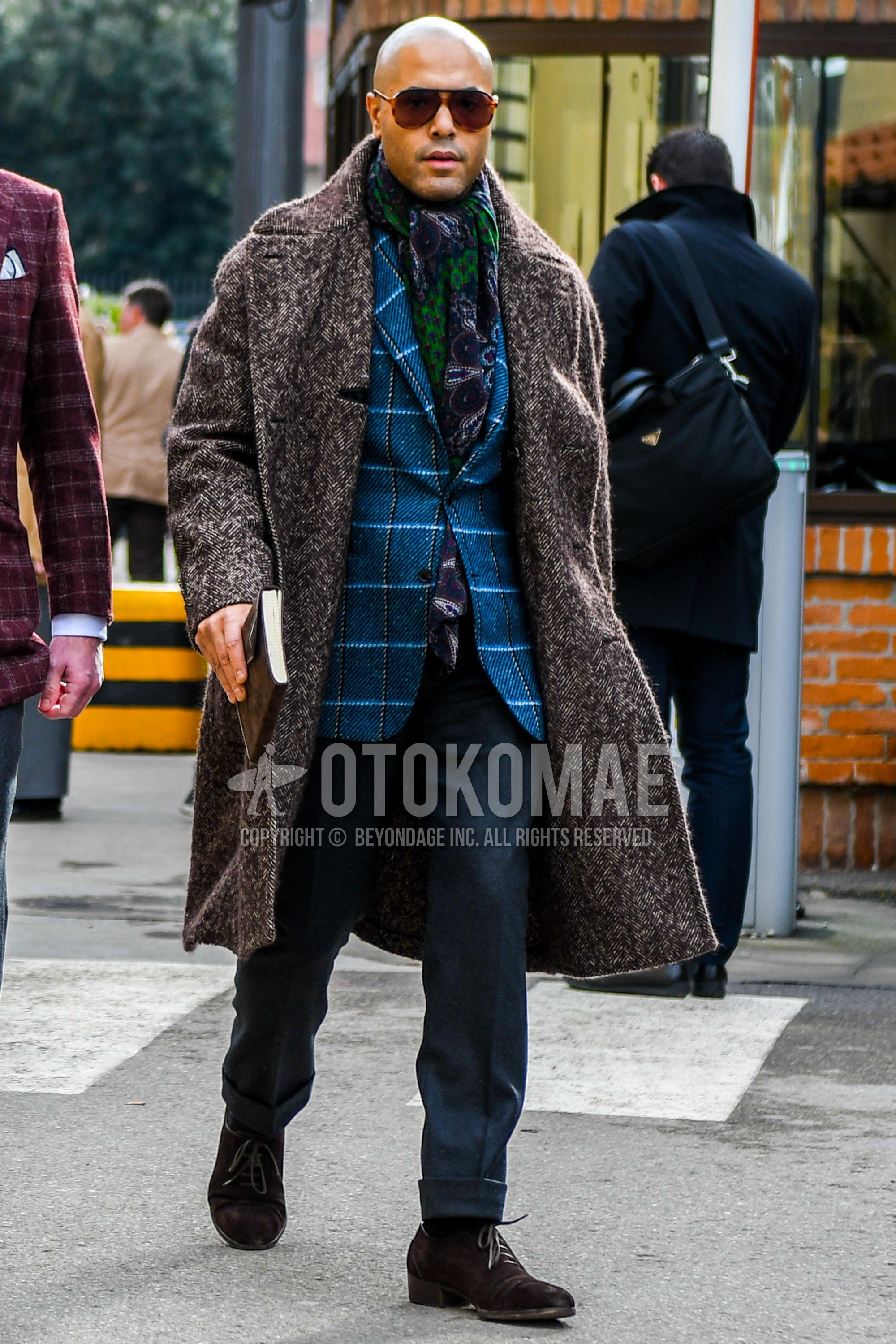 Men's autumn winter outfit with plain sunglasses, multi-color scarf scarf, brown outerwear chester coat, blue check tailored jacket, gray plain slacks, brown suede shoes leather shoes, plain toe leather shoes.