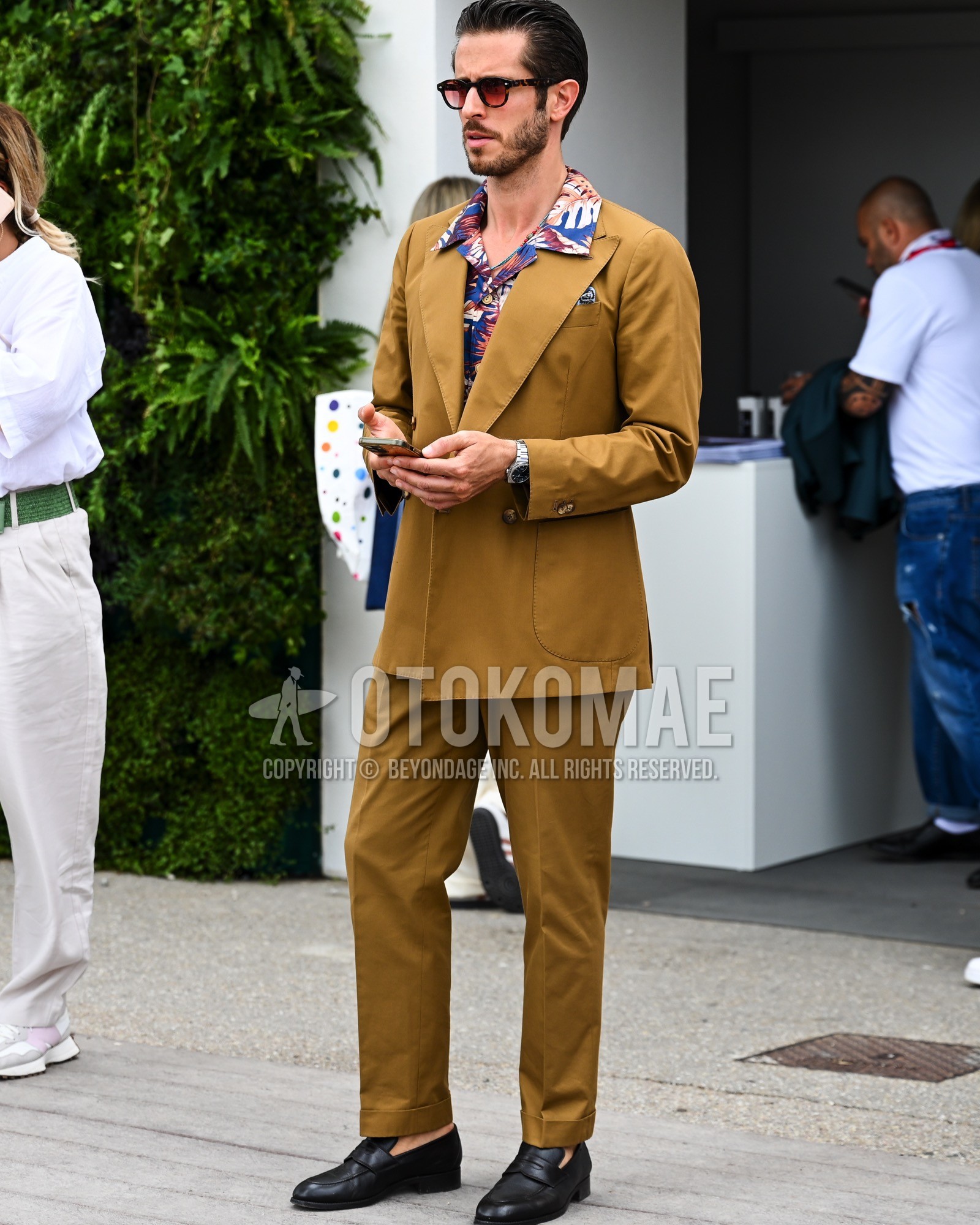 Men's spring summer autumn outfit with brown plain sunglasses, blue whole pattern shirt, black coin loafers leather shoes, brown plain suit.