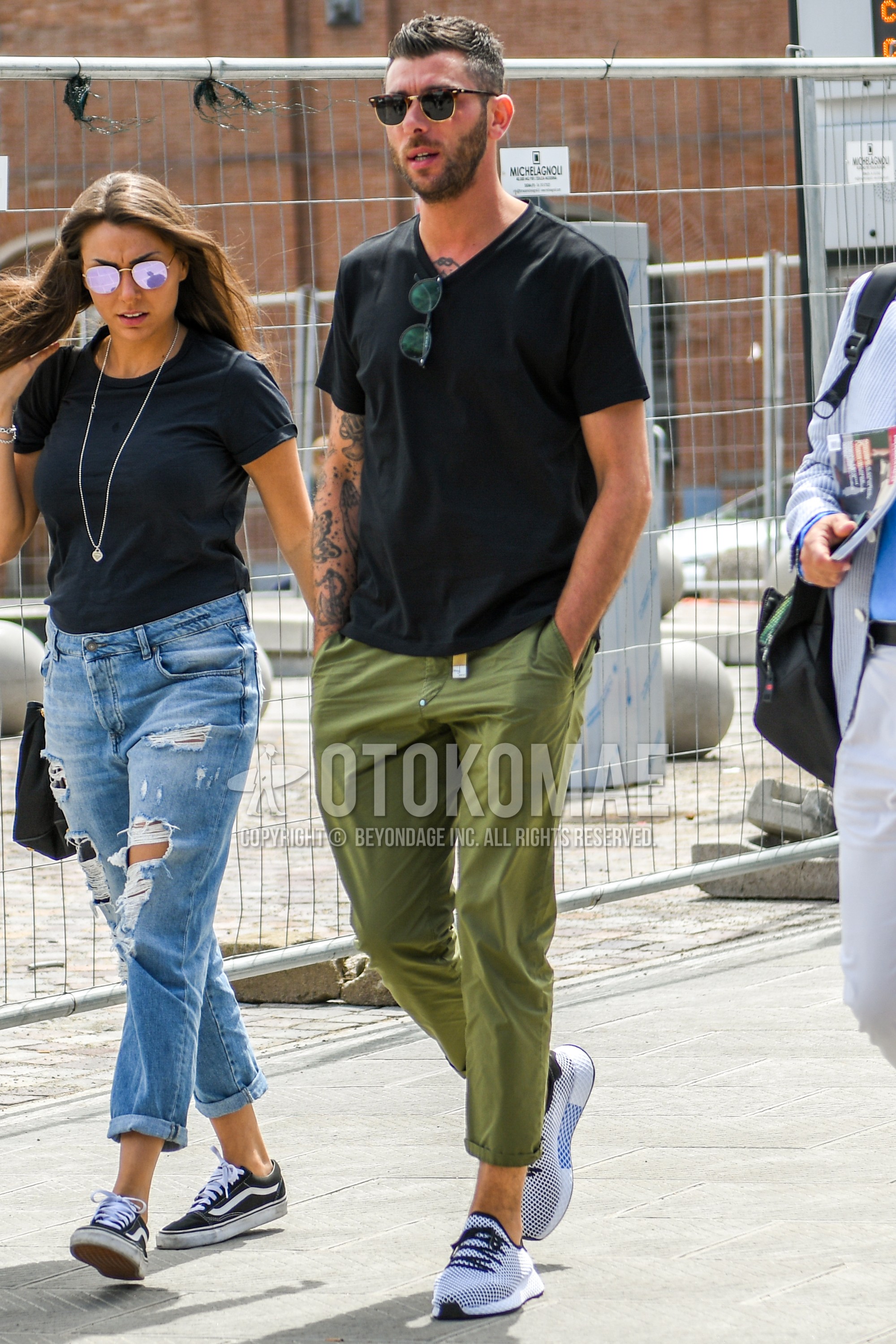 Men's summer outfit with plain sunglasses, black plain t-shirt, olive green plain ankle pants, white low-cut sneakers.