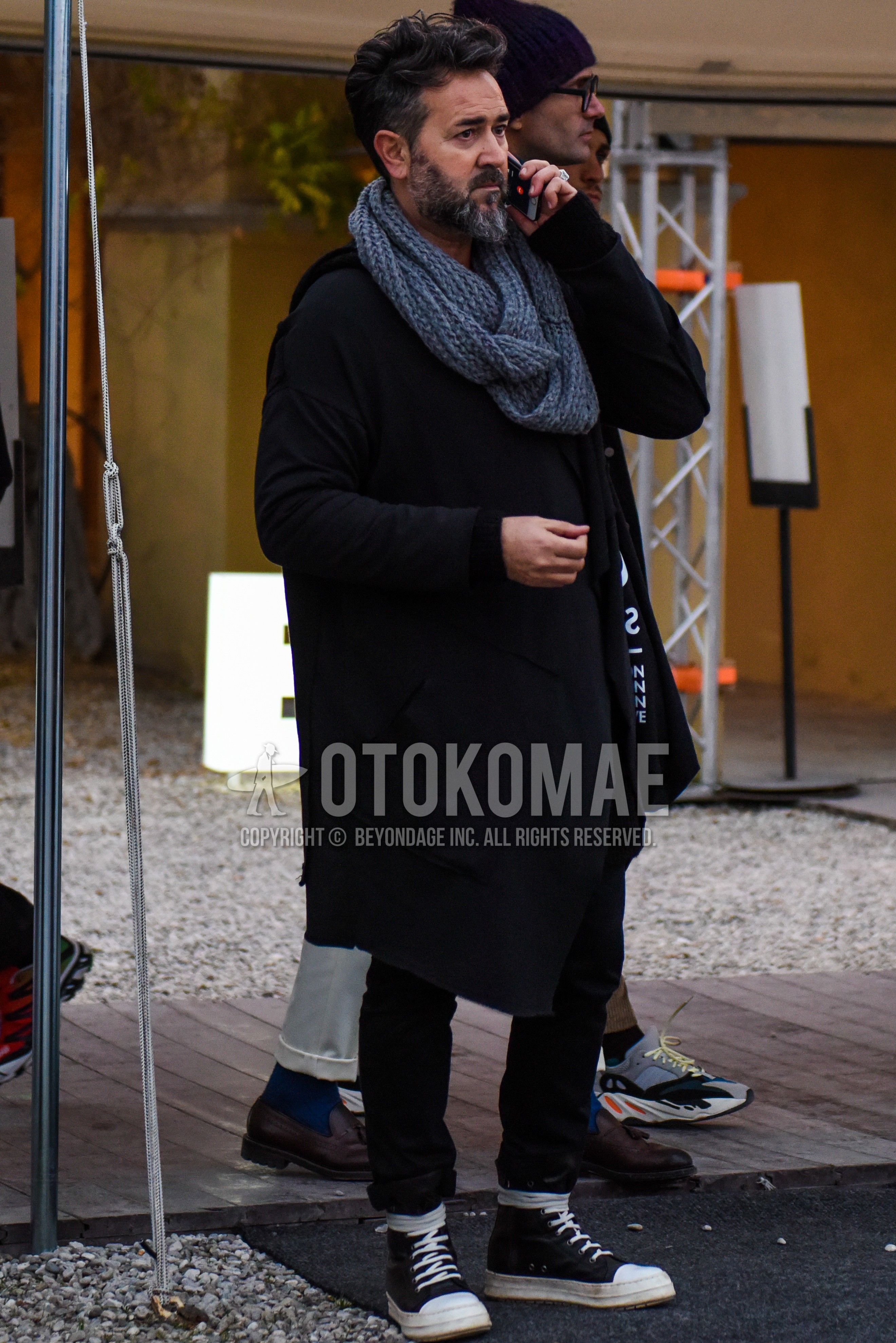 Men's winter outfit with gray plain snood, black plain outerwear, black plain cotton pants, black high-cut sneakers.
