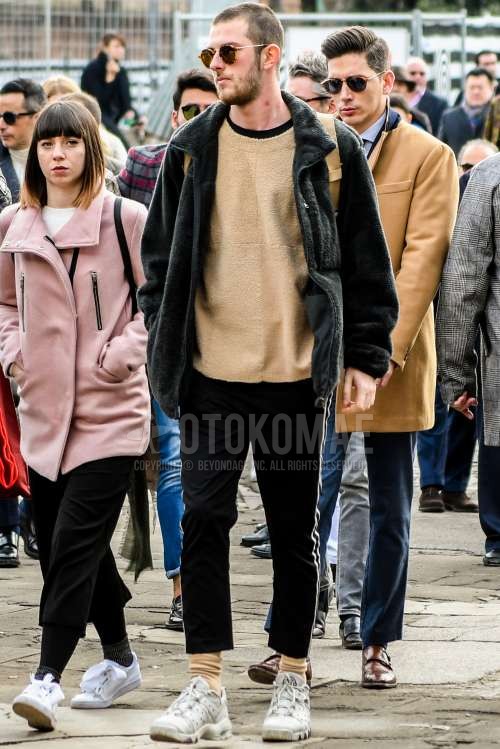 無地のサングラス、黒無地のフリースジャケット、ベージュ無地のTシャツ、黒無地のサイドラインパンツ、ベージュ無地のソックス、白ローカットのスニーカーを合わせた春秋のメンズコーデ・着こなし。