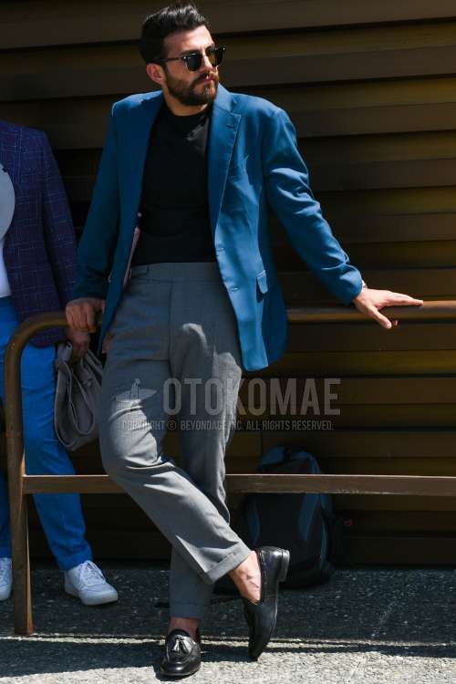 レイバン クラブマスターの黒無地のサングラス、ブルー無地のテーラードジャケット、黒無地のTシャツ、グレー無地のベルトレスパンツ、グレー無地のスラックス、黒タッセルローファーの革靴を合わせた夏春秋のメンズコーデ・着こなし。