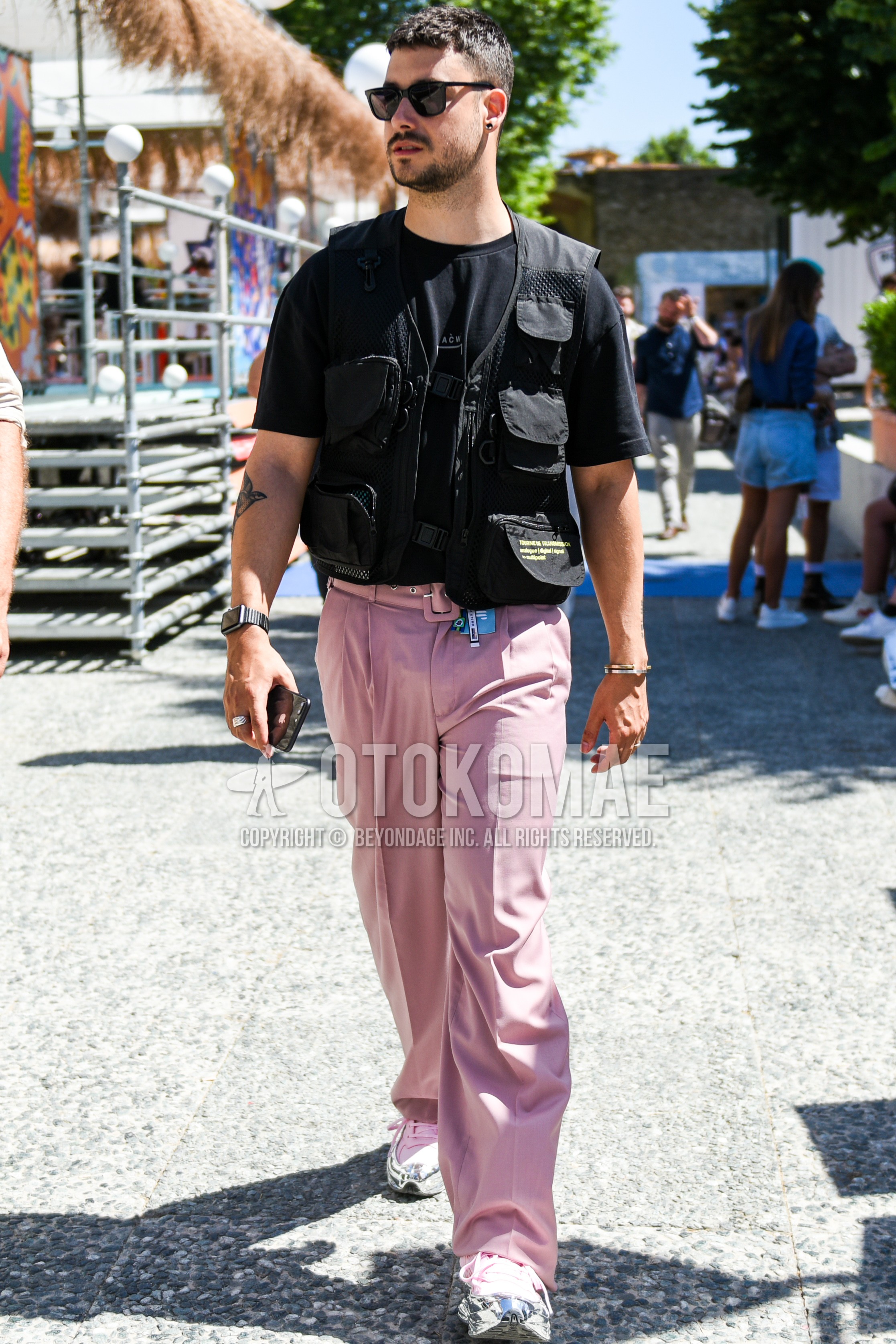 Men's summer outfit with black plain sunglasses, black plain casual vest, black one point t-shirt, pink plain slacks, plain pleated pants, silver pink low-cut sneakers.