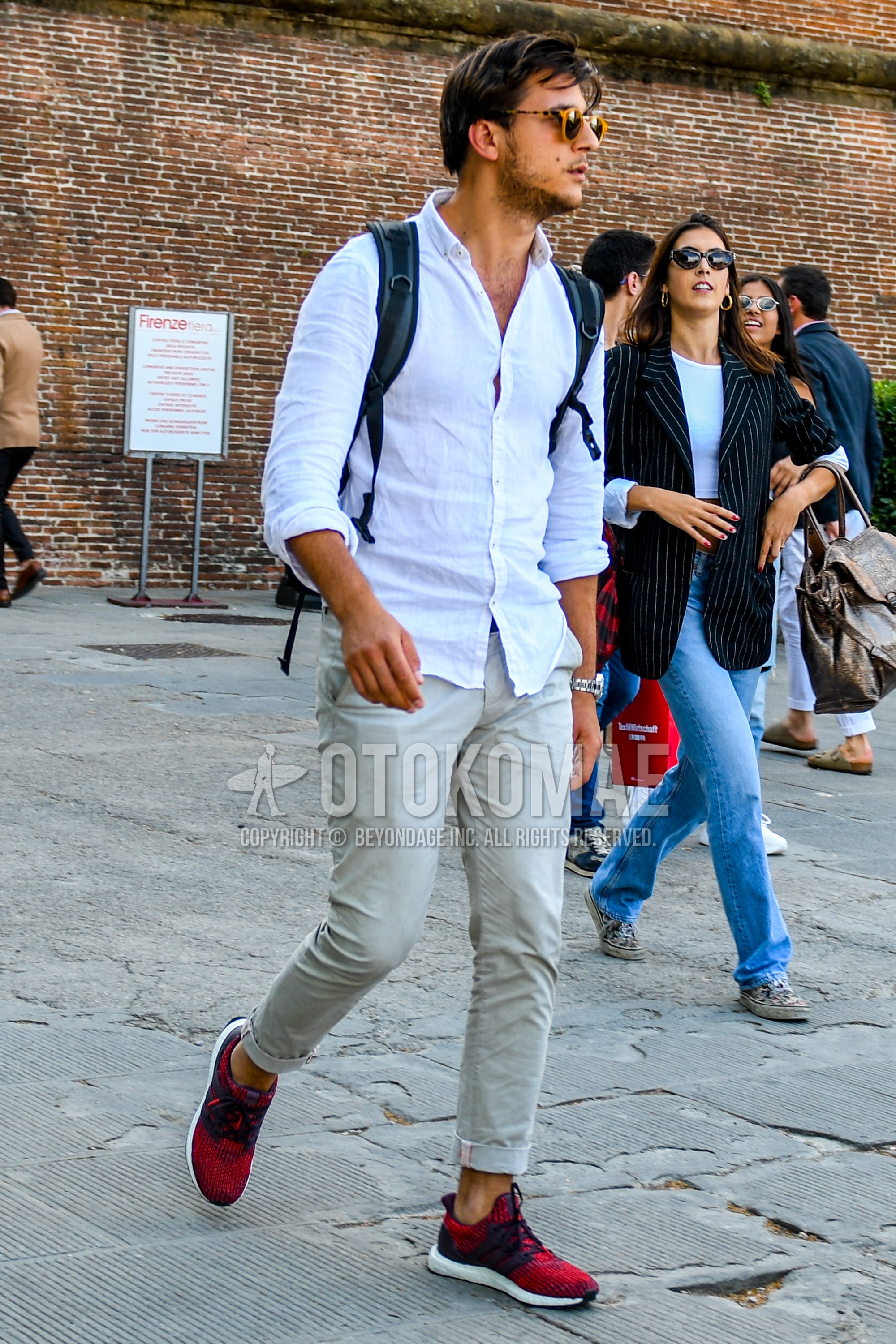 Men's spring summer outfit with tortoiseshell sunglasses, white plain shirt, beige plain chinos, red low-cut sneakers.