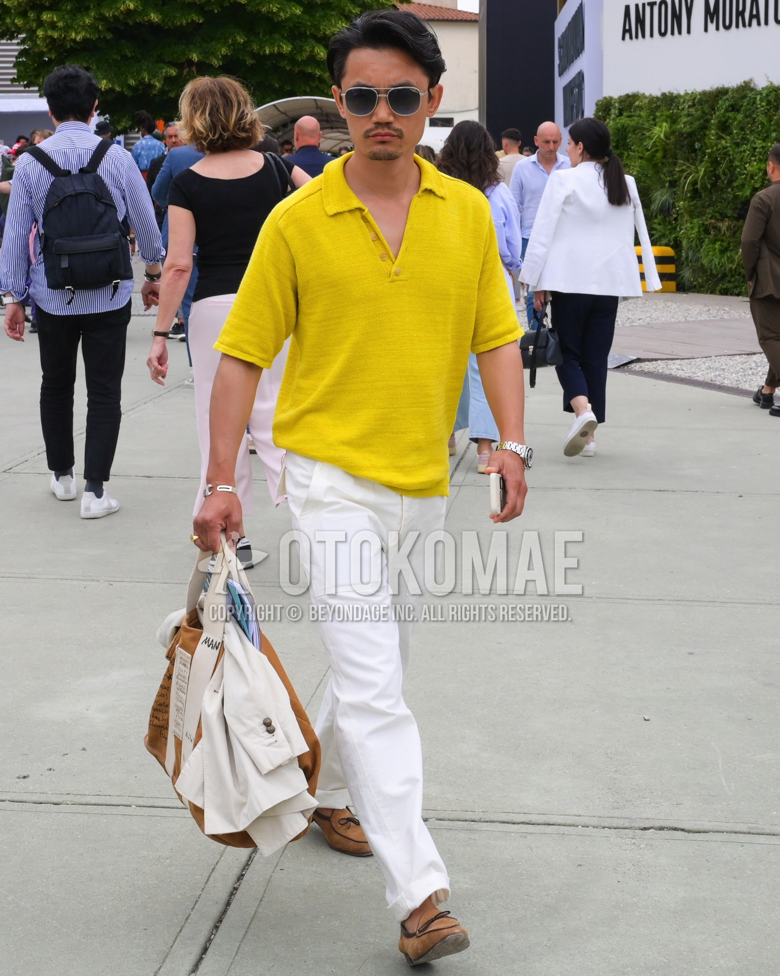 Men's spring summer outfit with black plain sunglasses, yellow plain polo shirt, white plain slacks, beige  loafers leather shoes, brown plain boston bag.