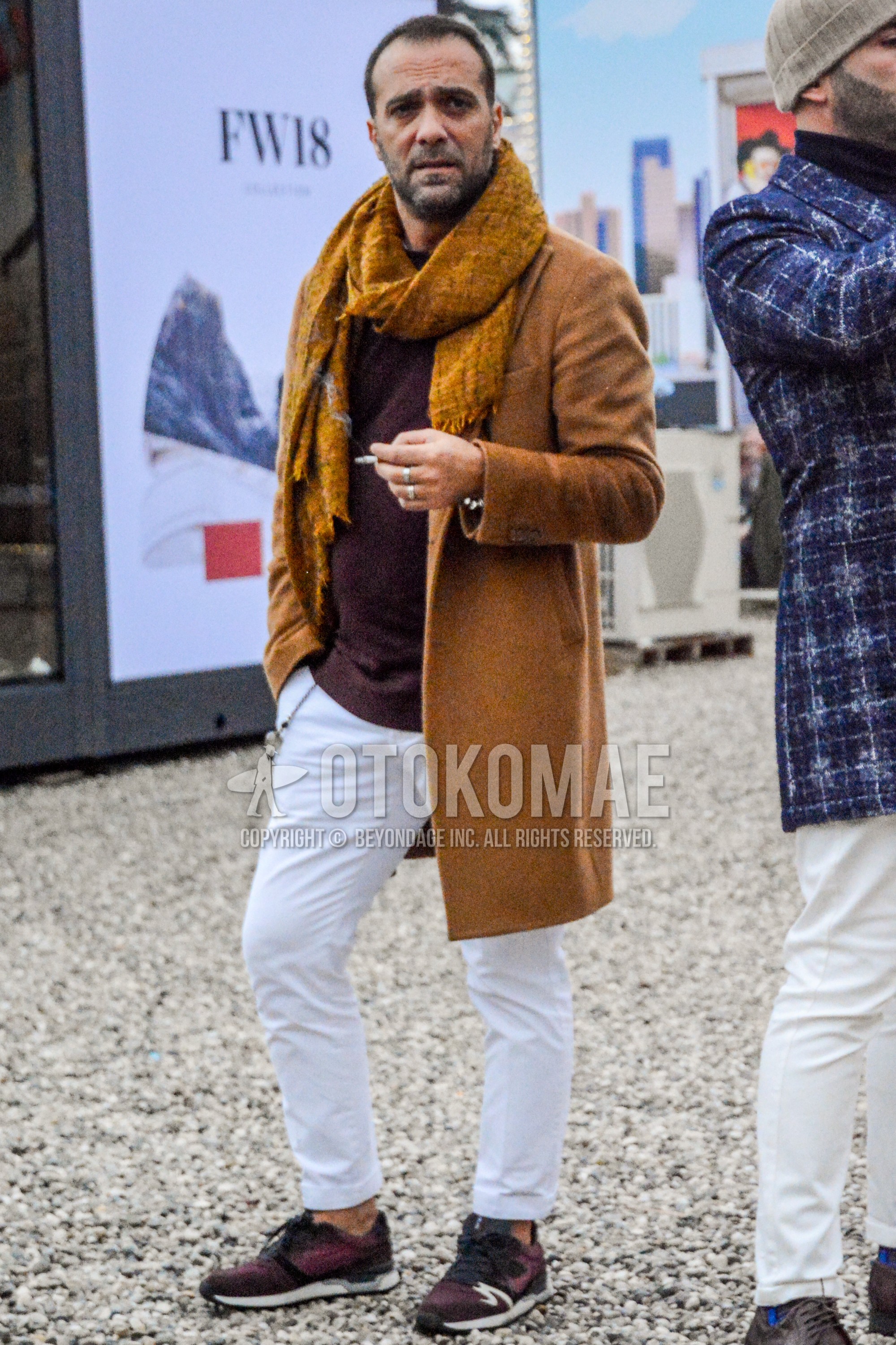 Men's winter outfit with brown plain scarf, brown plain chester coat, brown plain sweater, white plain cotton pants, red low-cut sneakers.