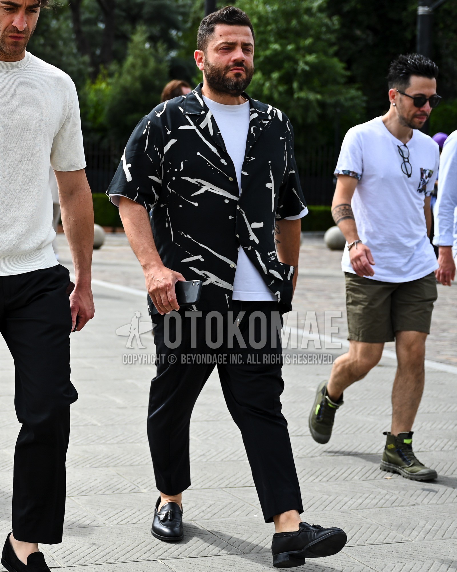 Men's spring summer outfit with black whole pattern shirt, white plain t-shirt, black plain easy pants, black tassel loafers leather shoes.