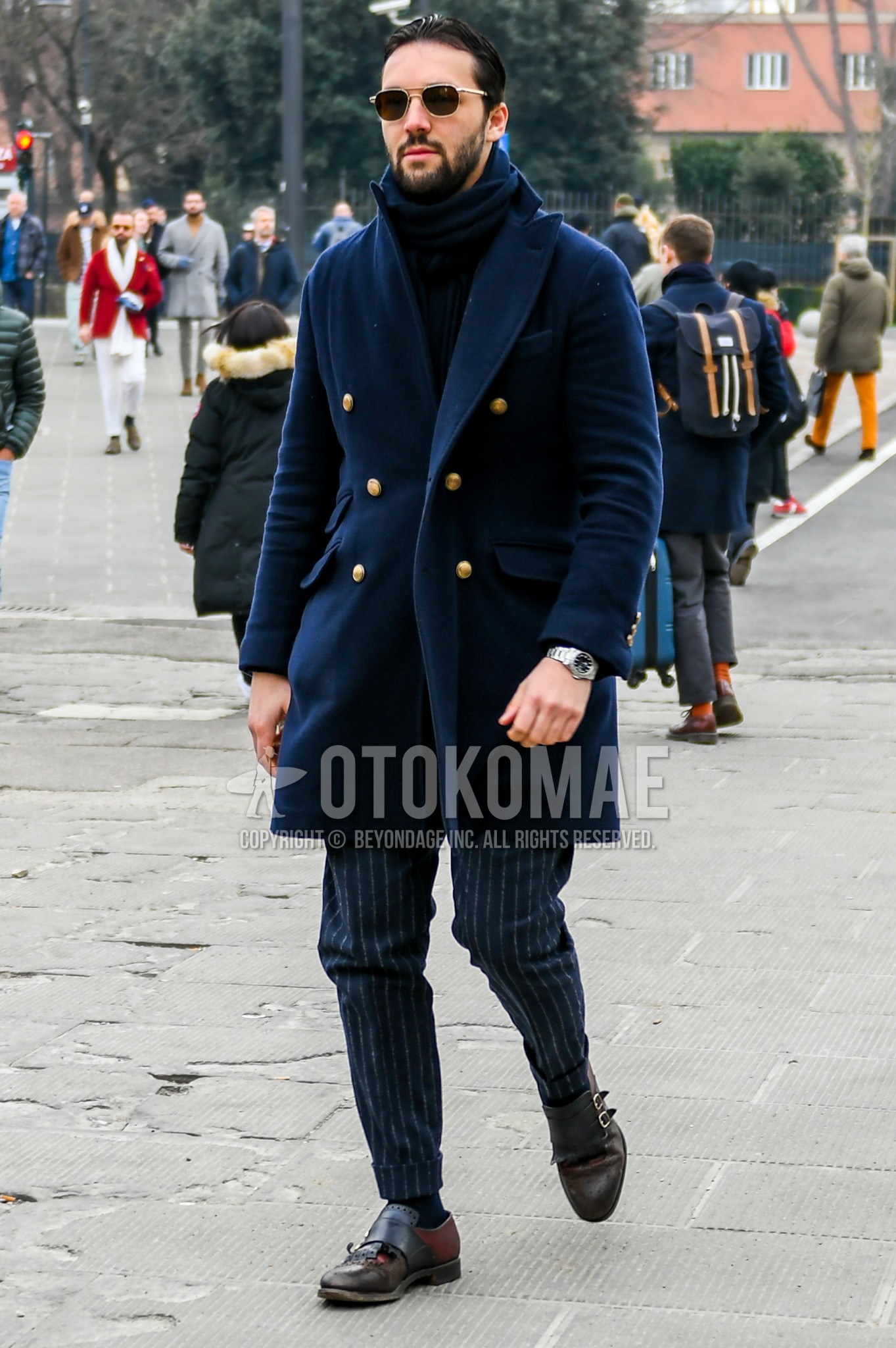 Men's winter outfit with plain sunglasses, plain scarf, navy plain chester coat, navy stripes slacks, brown monk shoes leather shoes.