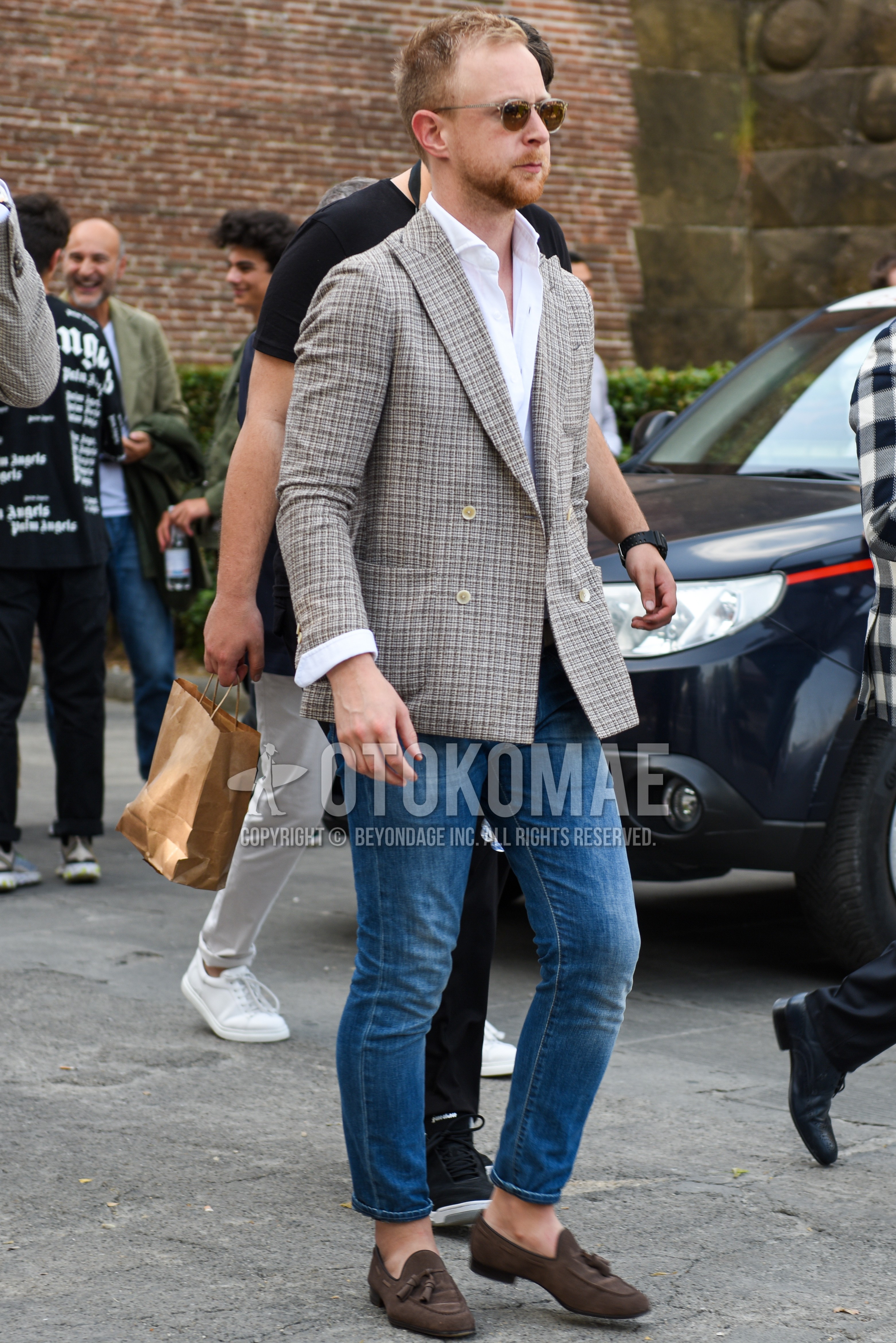 Men's spring summer autumn outfit with clear plain sunglasses, beige check tailored jacket, white plain shirt, blue plain denim/jeans, brown tassel loafers leather shoes.