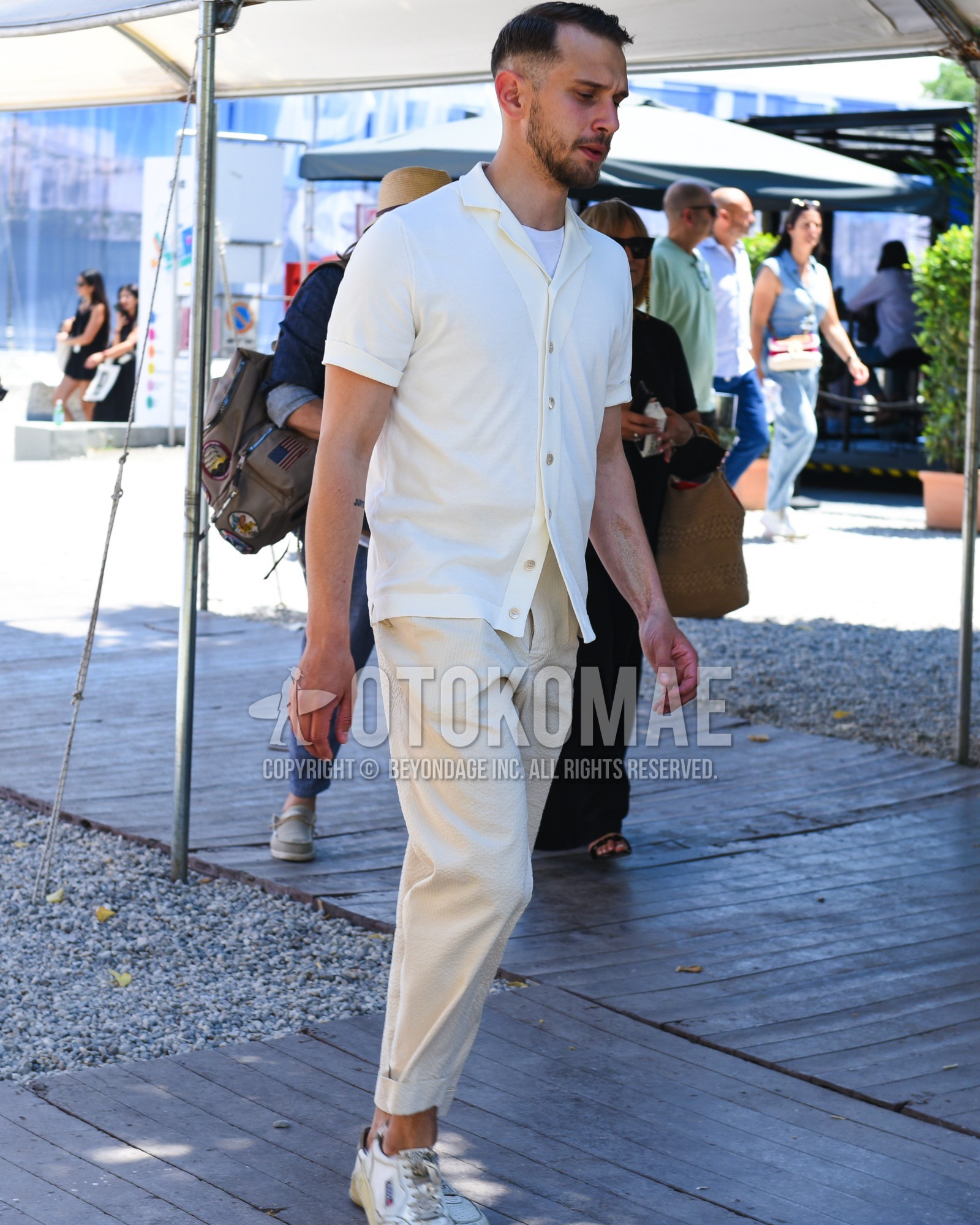 Men's spring summer outfit with white plain t-shirt, white plain cardigan, beige plain slacks, white low-cut sneakers.