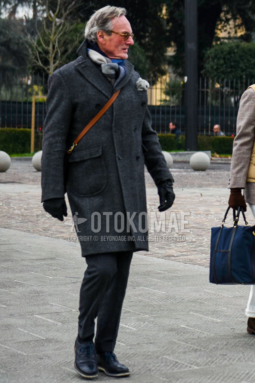 Men's winter outfit with brown plain sunglasses, gray white black scarf scarf, gray plain ulster coat, gray plain slacks, black plain socks, navy wing-tip shoes leather shoes, brown plain shoulder bag.