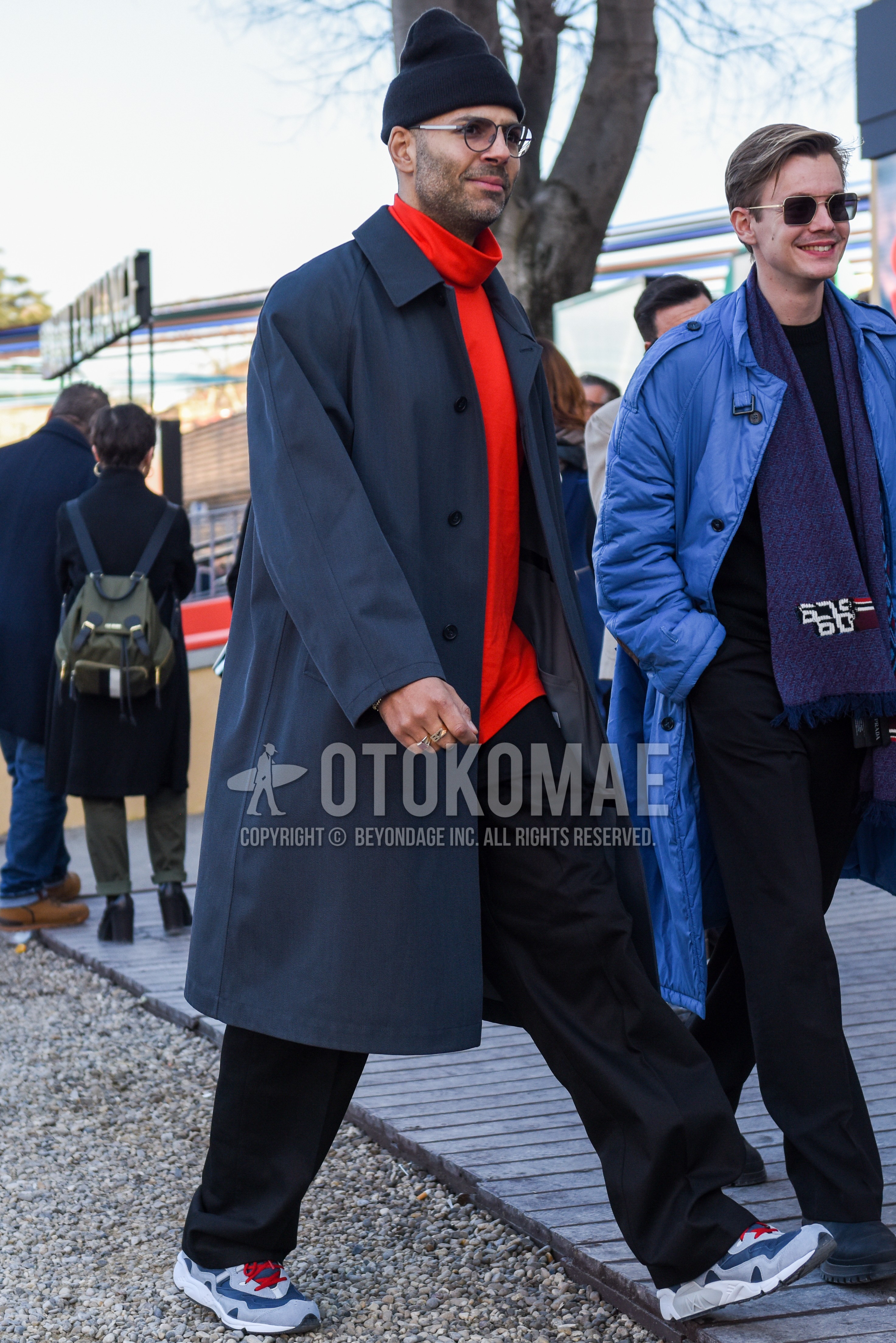Men's autumn winter outfit with black plain knit cap, black plain glasses, navy plain stenkarrer coat, red plain turtleneck knit, black plain slacks, gray low-cut sneakers.