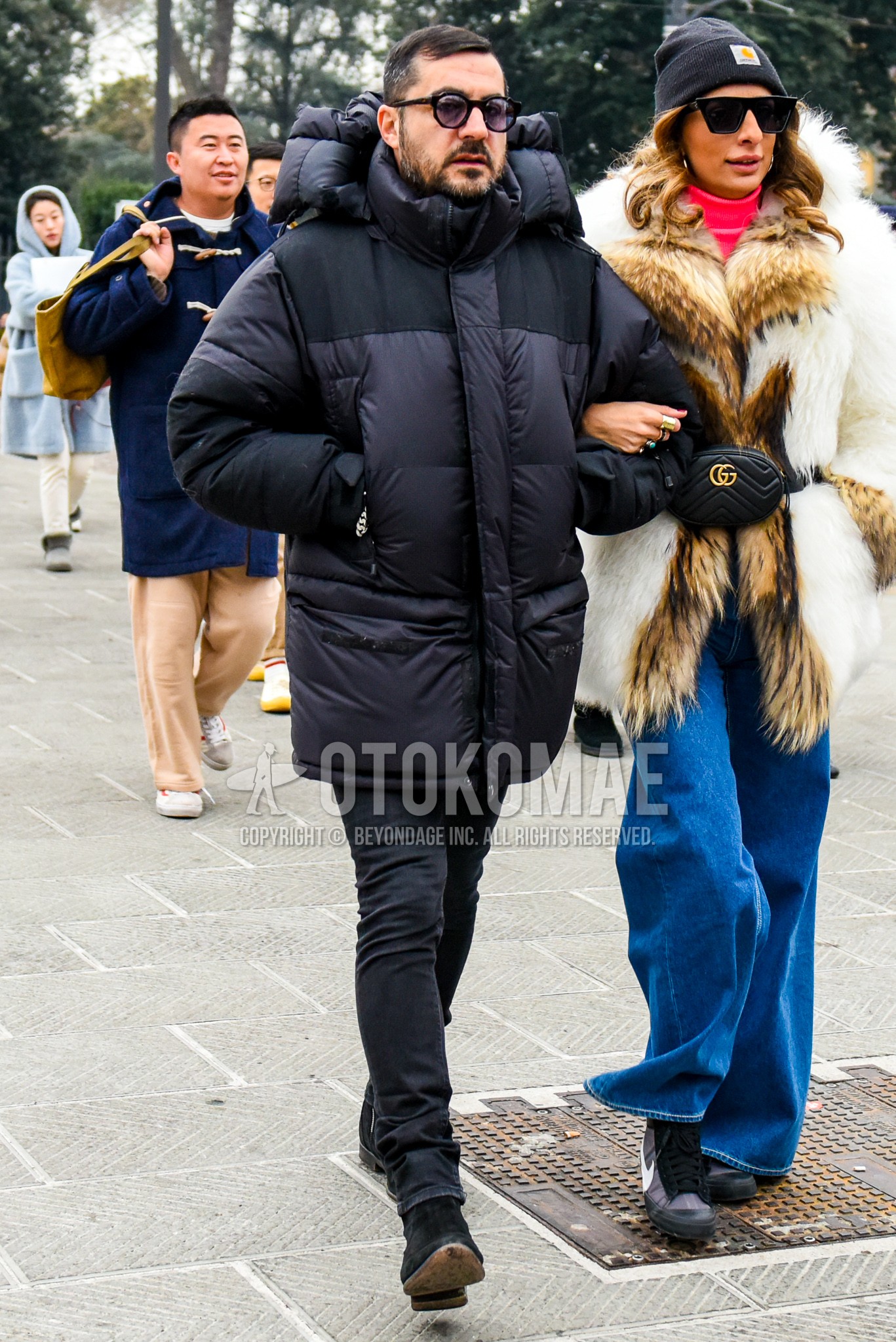 Men's winter outfit with black plain sunglasses, black plain down jacket, dark gray plain denim/jeans, black  boots.