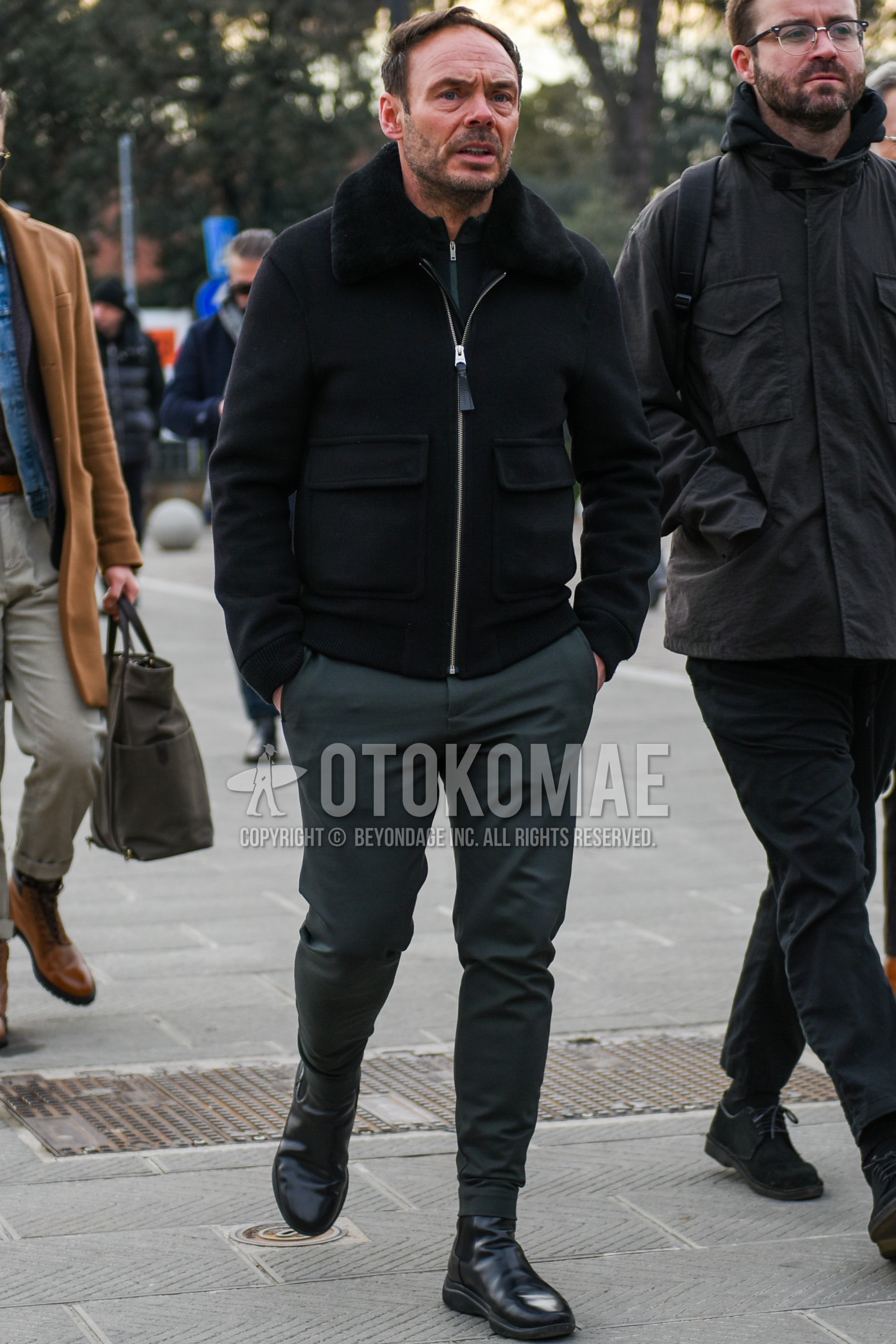 Men's autumn winter outfit with black plain military jacket, gray plain slacks, black side-gore boots.