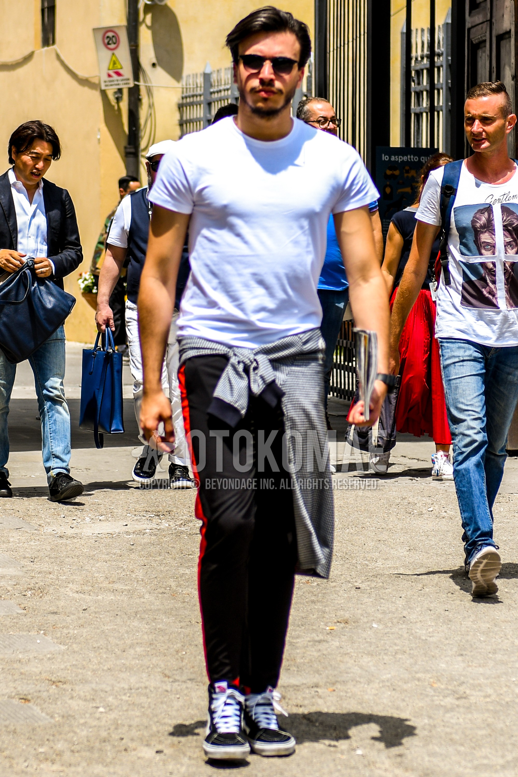 Men's summer outfit with plain sunglasses, white plain t-shirt, black plain sideline pants, black high-cut sneakers.