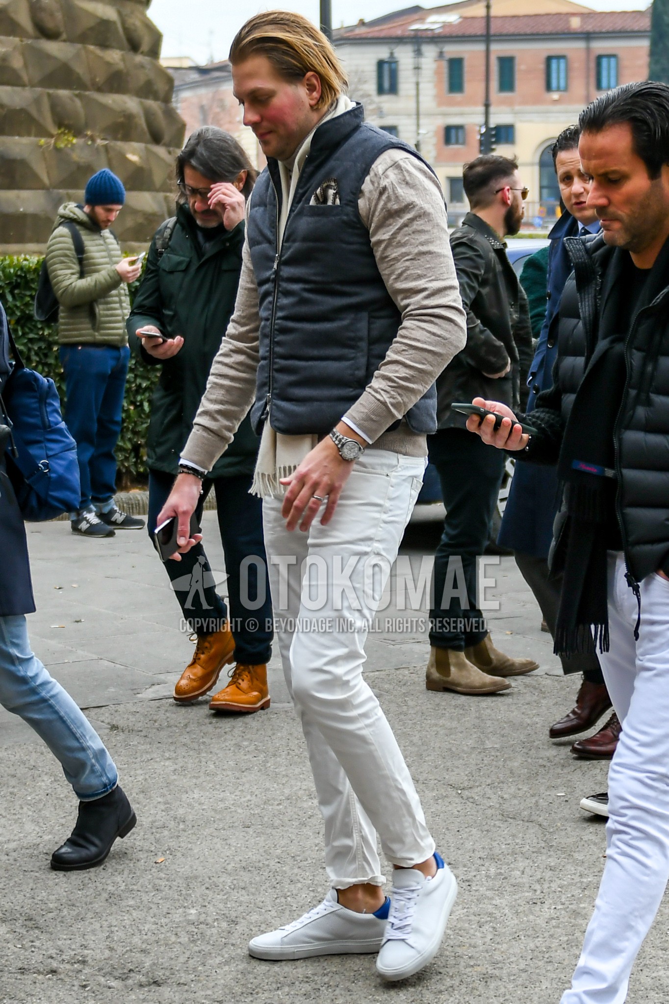 Men's autumn winter outfit with white plain scarf, gray plain down jacket, beige plain turtleneck knit, white plain denim/jeans, white low-cut sneakers.