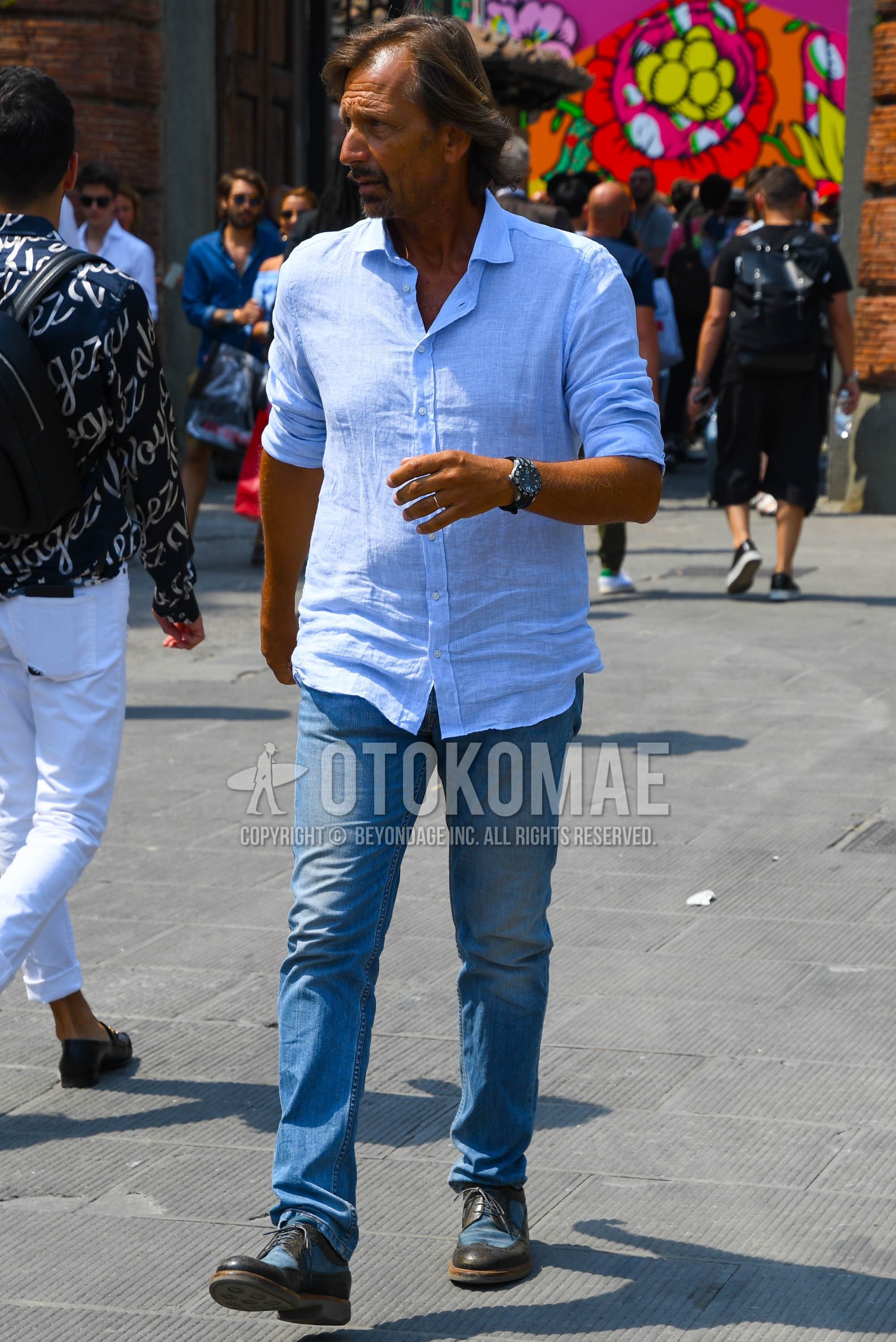 Men's spring summer outfit with white plain shirt, blue plain denim/jeans, blue brown wing-tip shoes leather shoes.