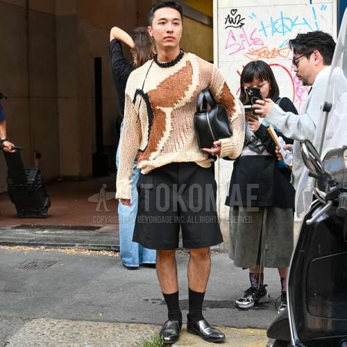 ベージュトップス/インナーのセーター、黒無地のショートパンツ、黒無地のソックス、黒の革靴、黒無地のブリーフケース/ハンドバッグを合わせた春秋のメンズコーデ・着こなし。