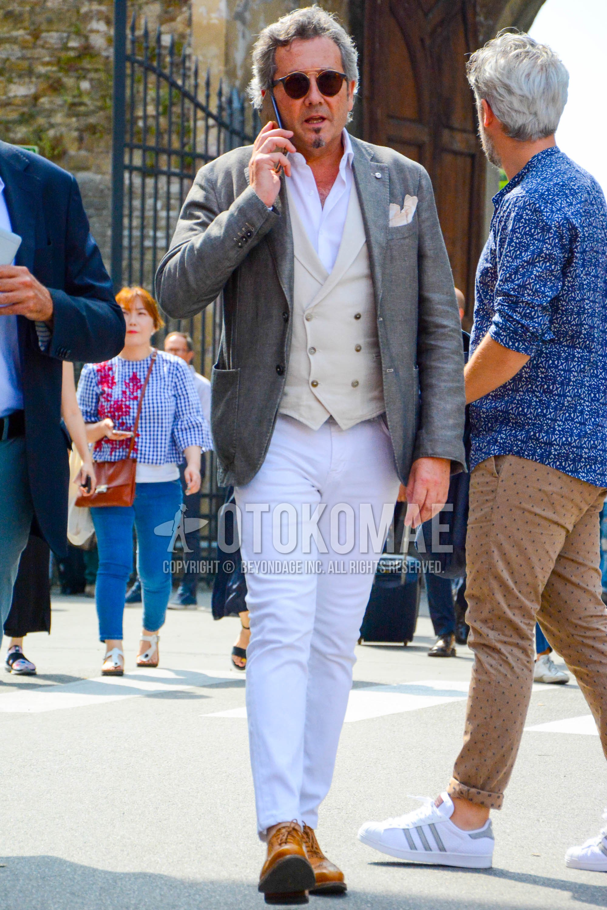 Men's spring autumn outfit with brown plain sunglasses, gray plain tailored jacket, white plain gilet, white plain shirt, white plain cotton pants, beige wing-tip shoes leather shoes.