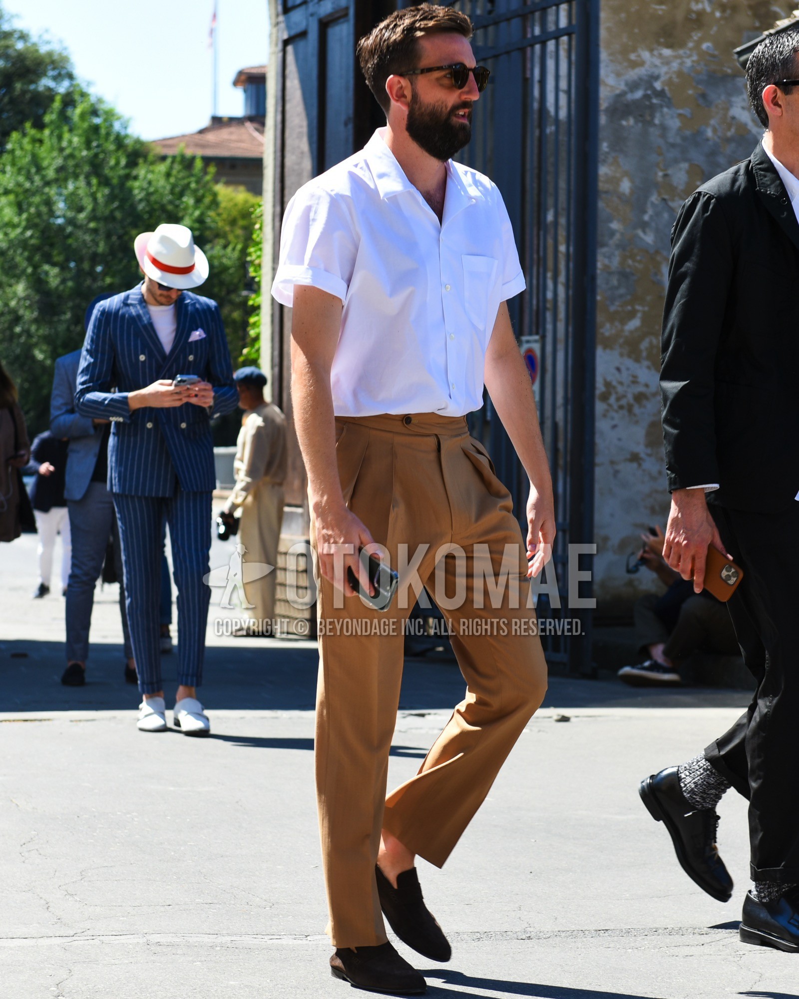 Men's spring summer outfit with brown tortoiseshell sunglasses, white plain shirt, brown plain slacks, brown coin loafers leather shoes, brown suede shoes leather shoes.