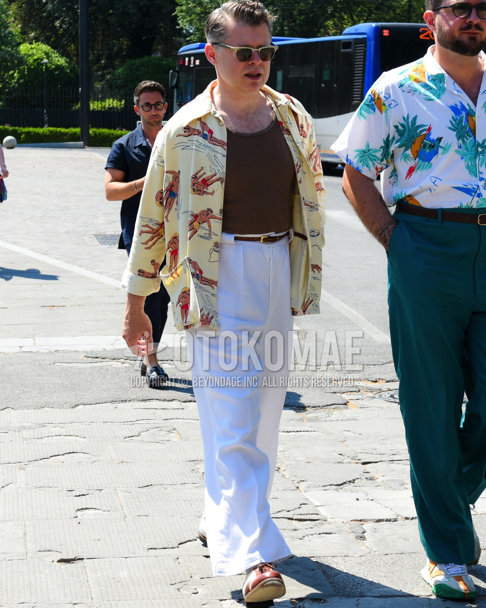 Men's spring summer outfit with gold green plain sunglasses, brown plain tank top, yellow graphic shirt, brown plain braided belt, white plain slacks, white plain wide pants, red white plain toe leather shoes.