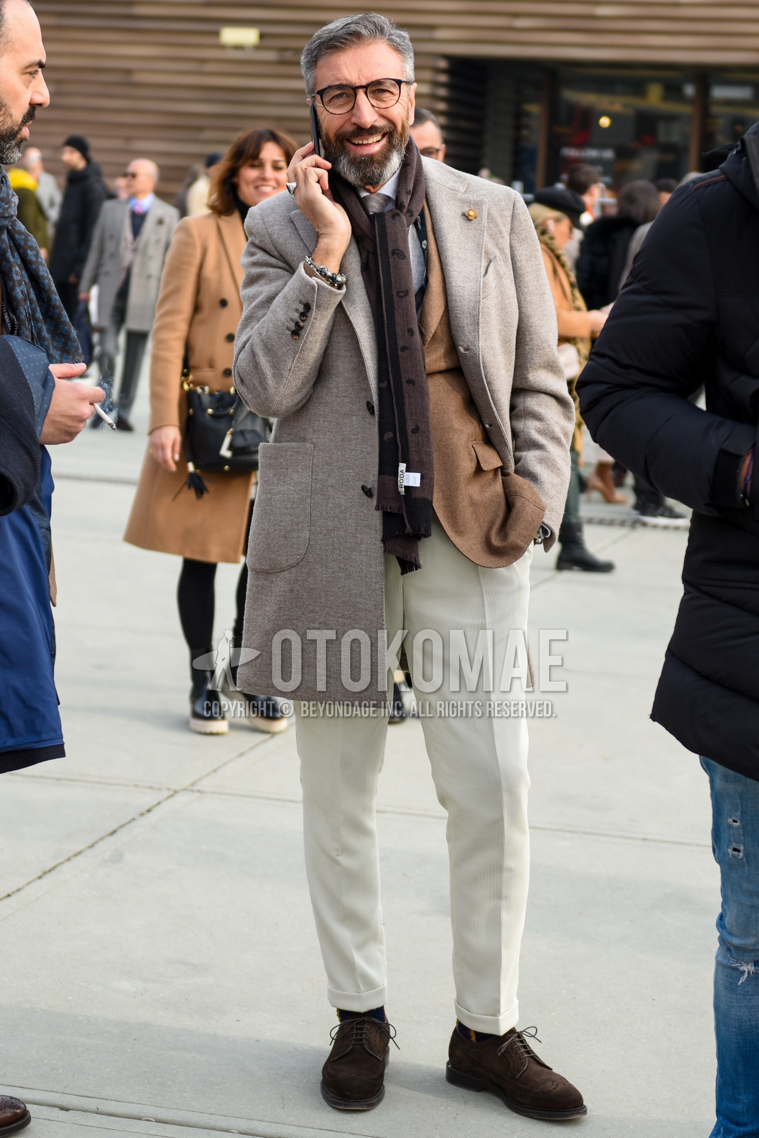 Men's autumn winter outfit with brown tortoiseshell glasses, brown paisley scarf, beige plain chester coat, brown plain tailored jacket, white plain shirt, white plain slacks, brown wing-tip shoes leather shoes, gray plain necktie.