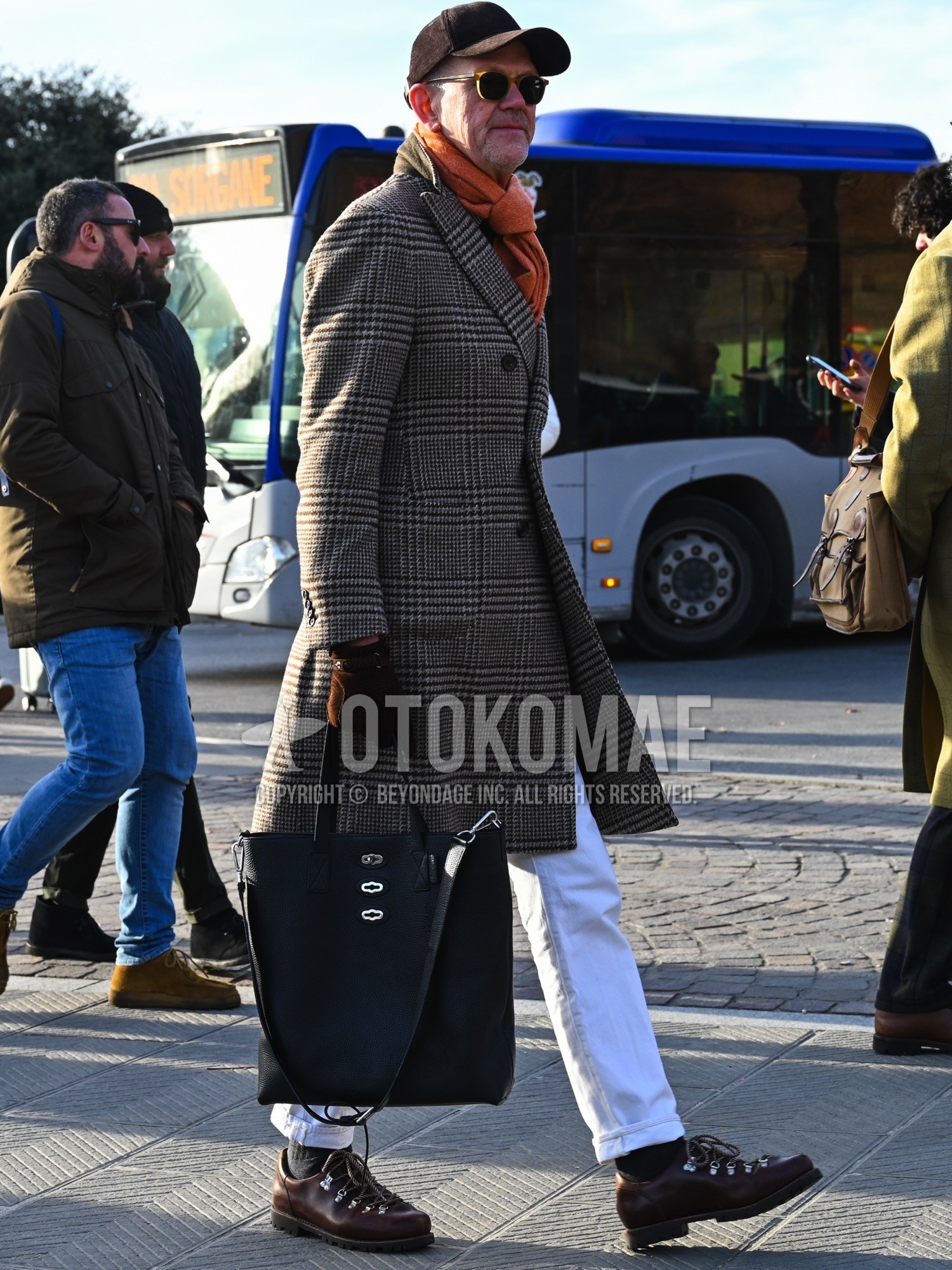 Men's autumn winter outfit with brown plain baseball cap, brown plain sunglasses, orange plain scarf, gray check chester coat, white plain cotton pants, brown work boots, black plain tote bag.