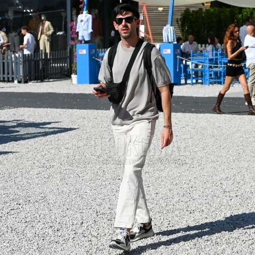 レイバン　ウェイファーラー　ウェリントンの黒無地のサングラス、ニットのグレー無地のTシャツ、白無地のチノパン、白・黒ローカットのスニーカー、黒無地のバックパック、黒無地のボディバッグを合わせた夏春のメンズコーデ・着こなし。