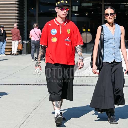 黒キャップのベースボールキャップ、グレー無地のサングラス、レッドワンポイントのポロシャツ、黒無地のショートパンツ、黒無地のプリーツパンツ、白無地のソックス、黒モカシン/デッキシューズの革靴を合わせた夏春のメンズコーデ・着こなし。