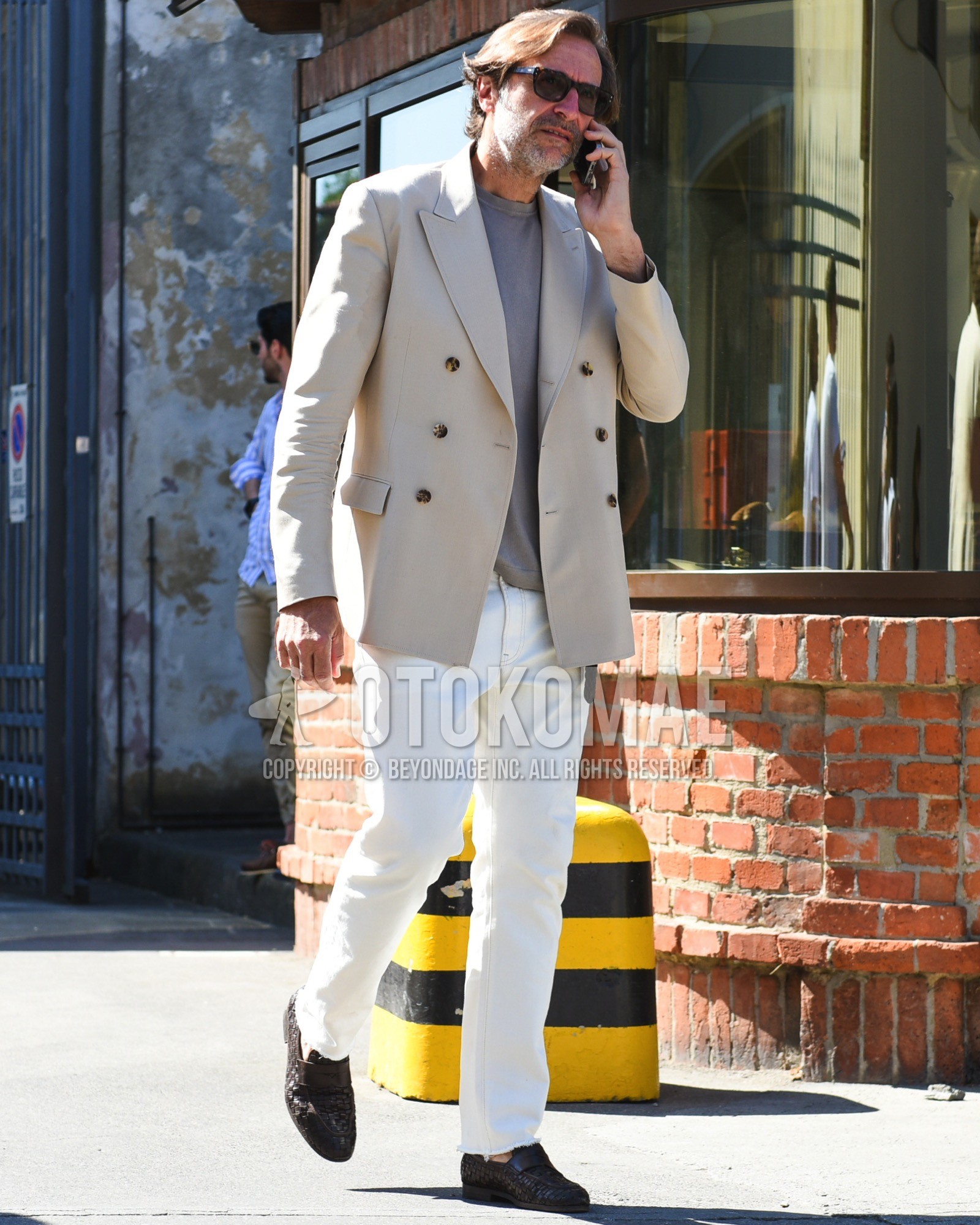 Men's spring summer outfit with brown tortoiseshell sunglasses, beige plain tailored jacket, gray plain t-shirt, white plain cotton pants, brown coin loafers leather shoes.
