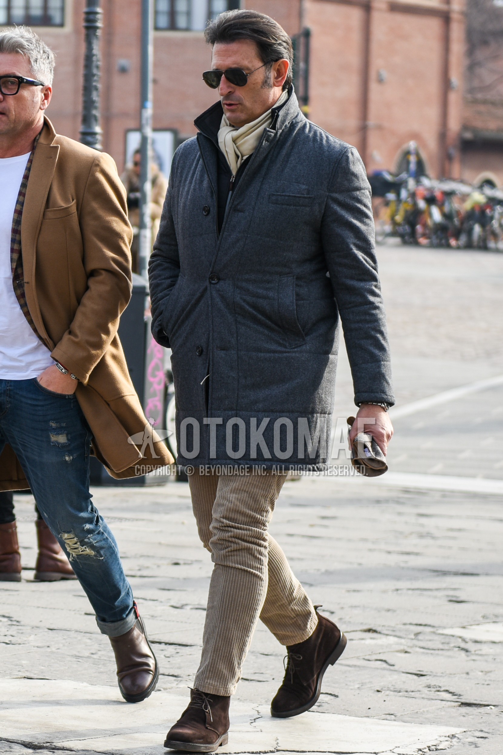 Men's autumn winter outfit with silver plain sunglasses, beige plain scarf, gray plain down jacket, gray plain chester coat, beige plain winter pants (corduroy,velour), brown chukka boots.